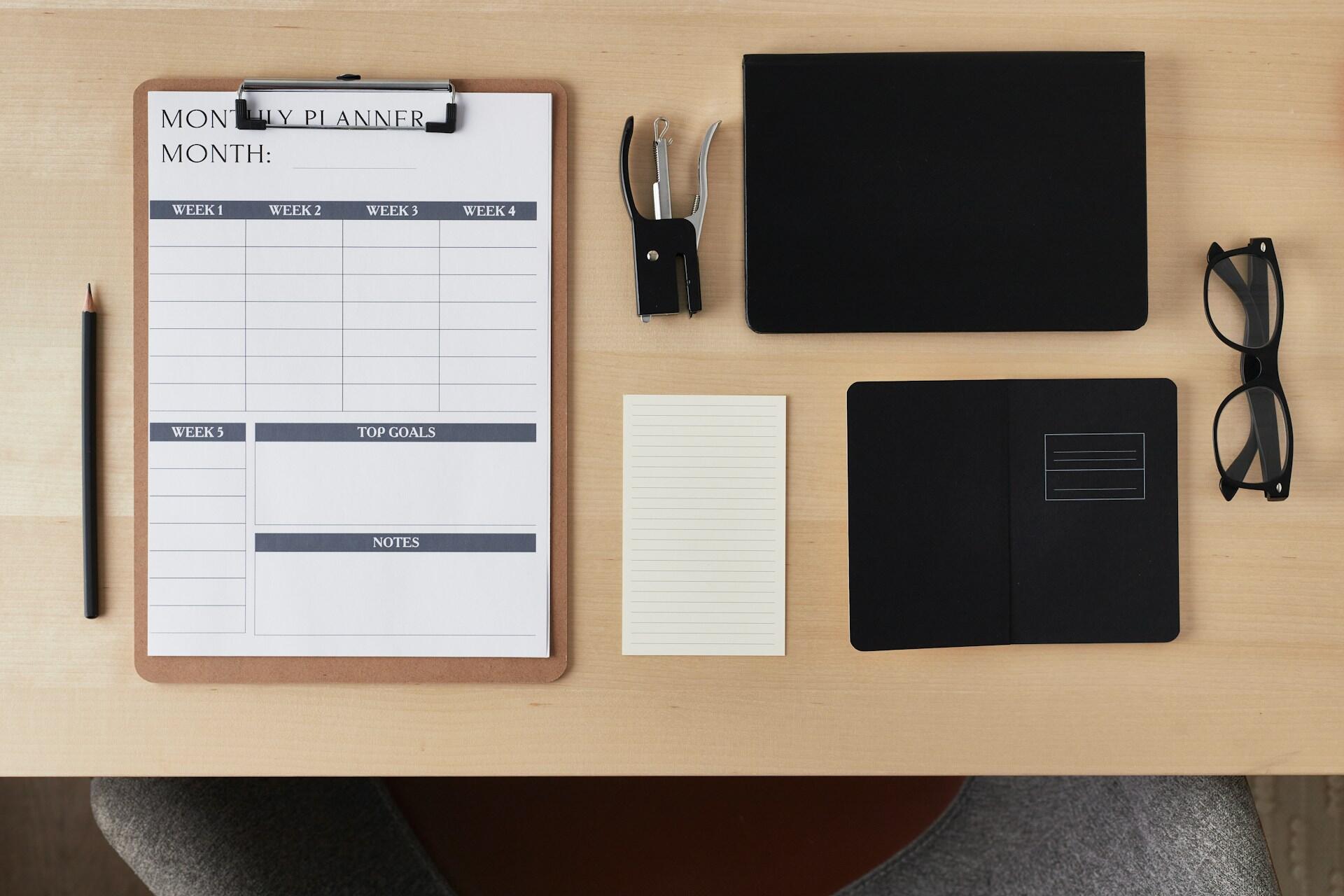 Assorted office equipment like clipboard and tablet precisely laid out.