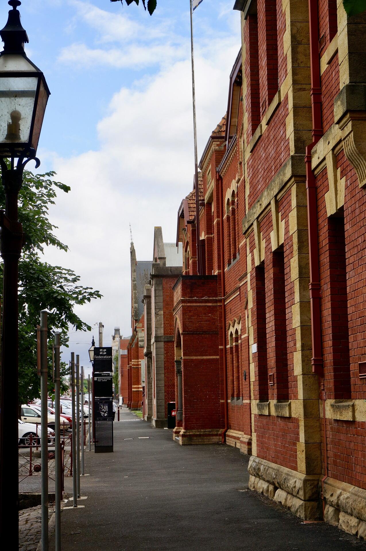 A street with a red brick building running alongside it.