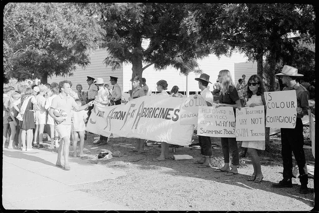 A group of protesters holding banners advocating for equal rights for Aboriginal people.
