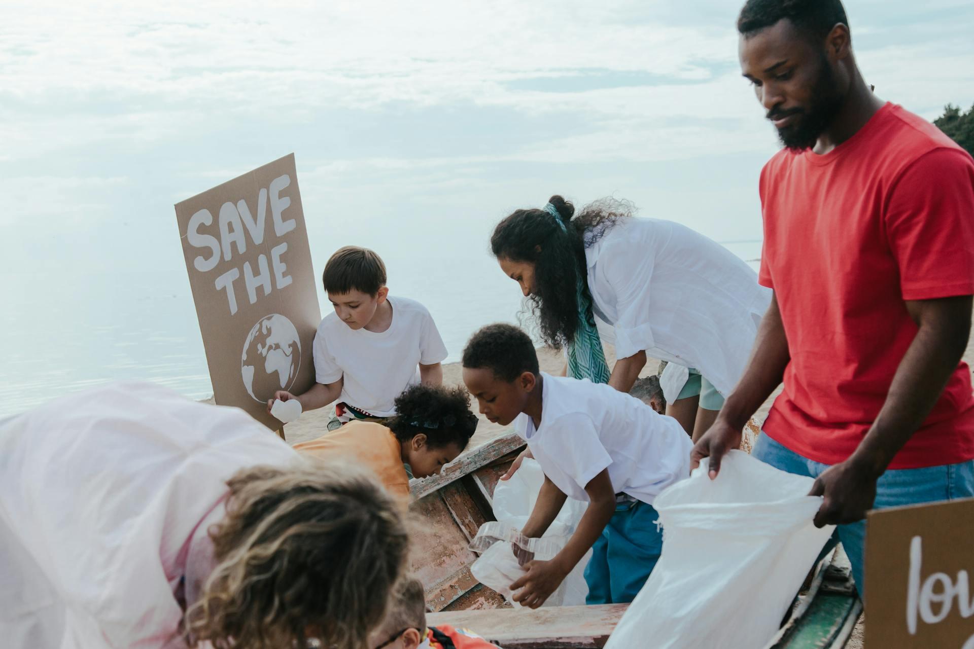 child and adult volunteers cleaning up a beach