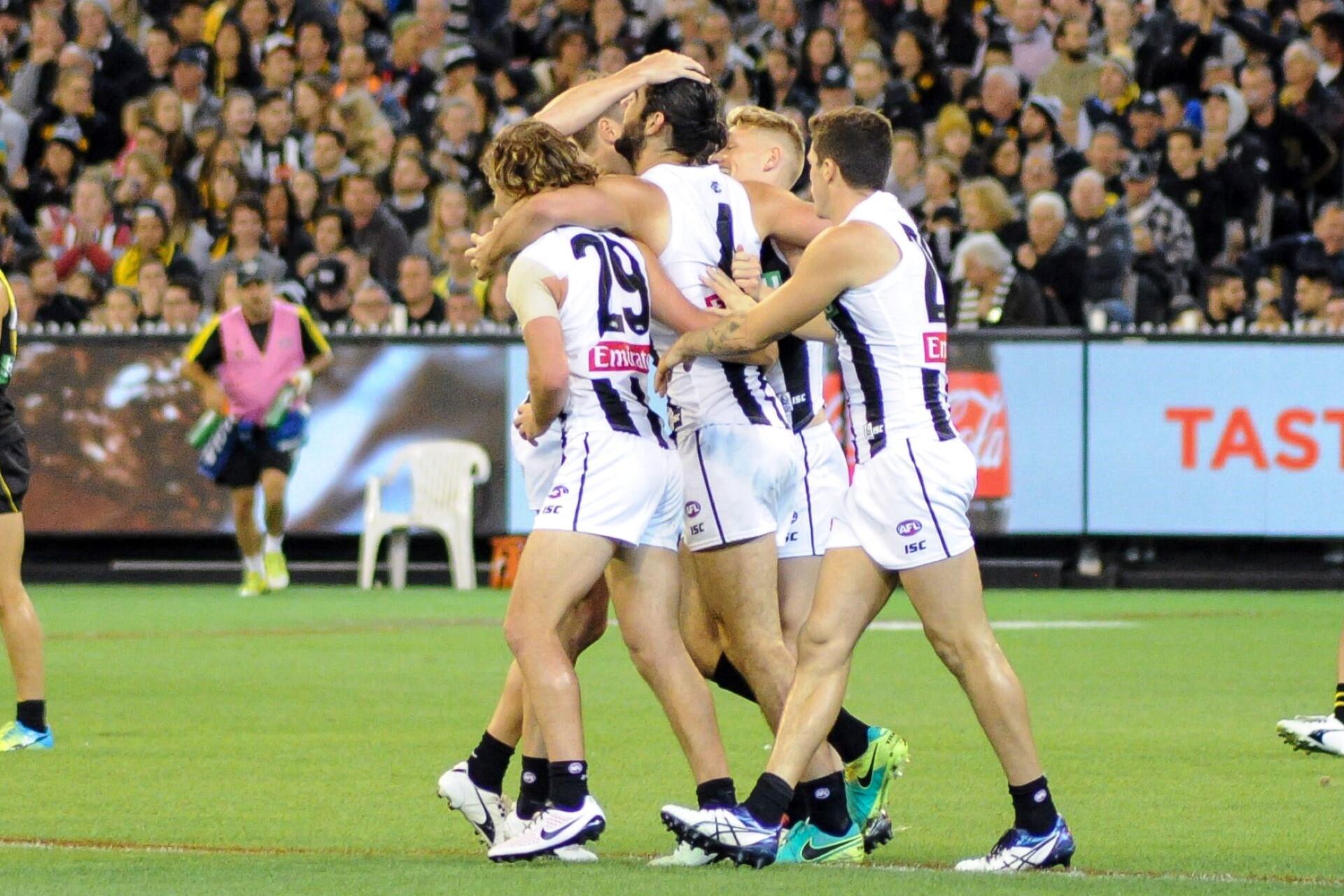 The Collingwood AFL team celebrating a goal.