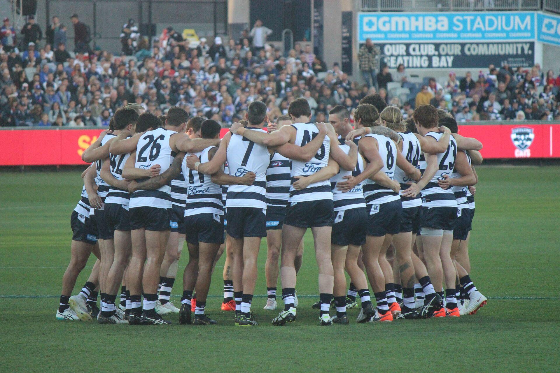 Geelong AFL team in a huddle.