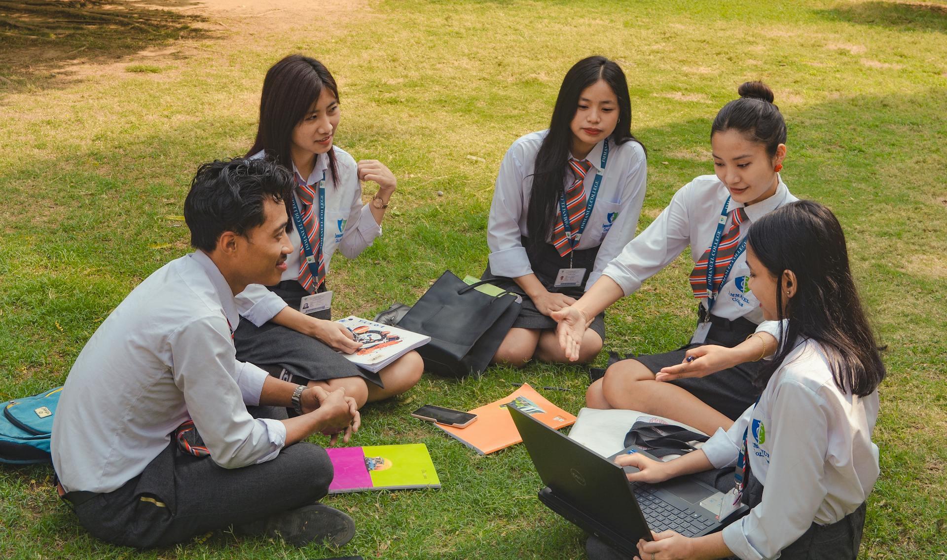 a group of Indian students in school uniforms working on homework