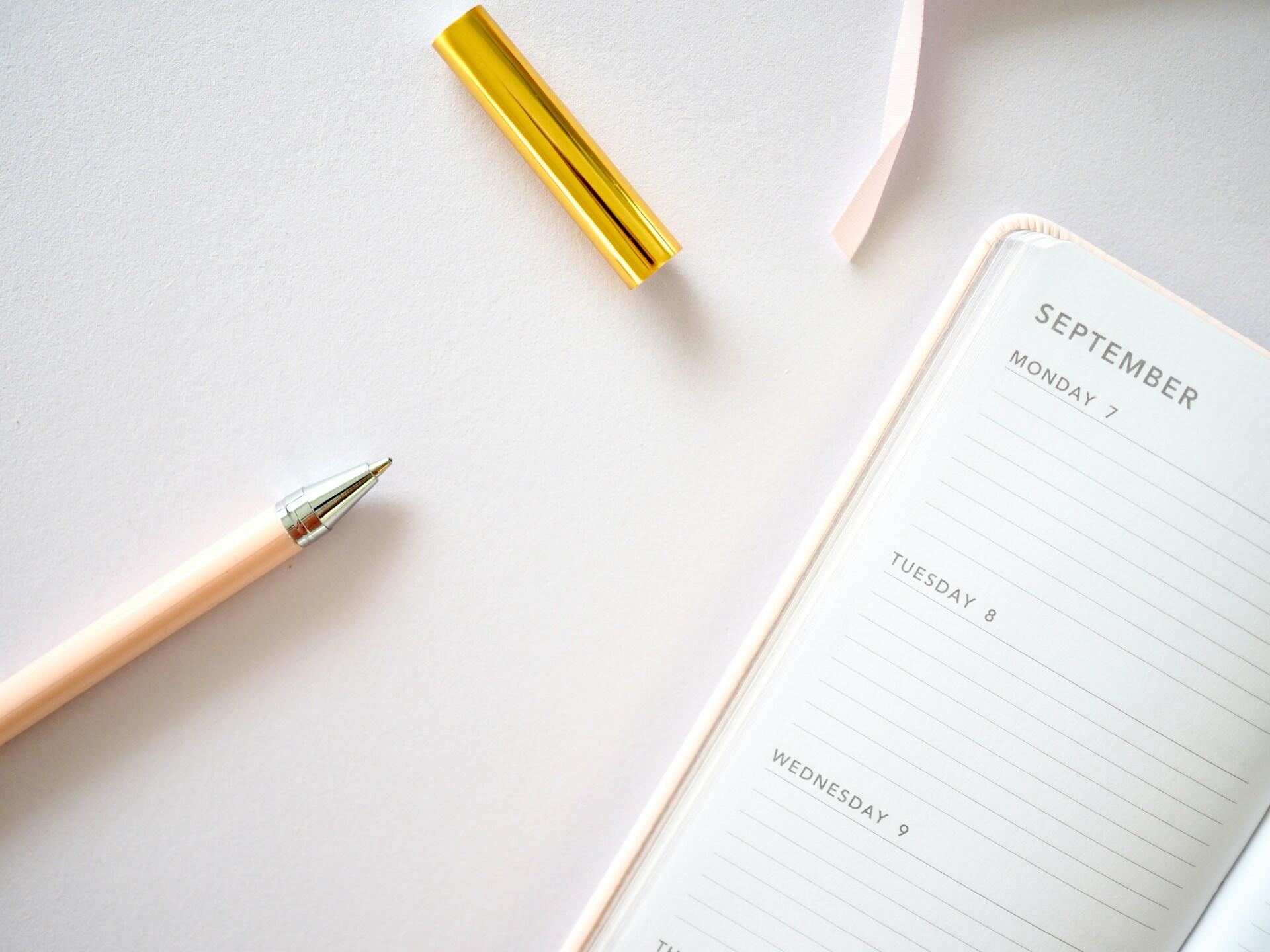 An open agenda with a pen next to it.