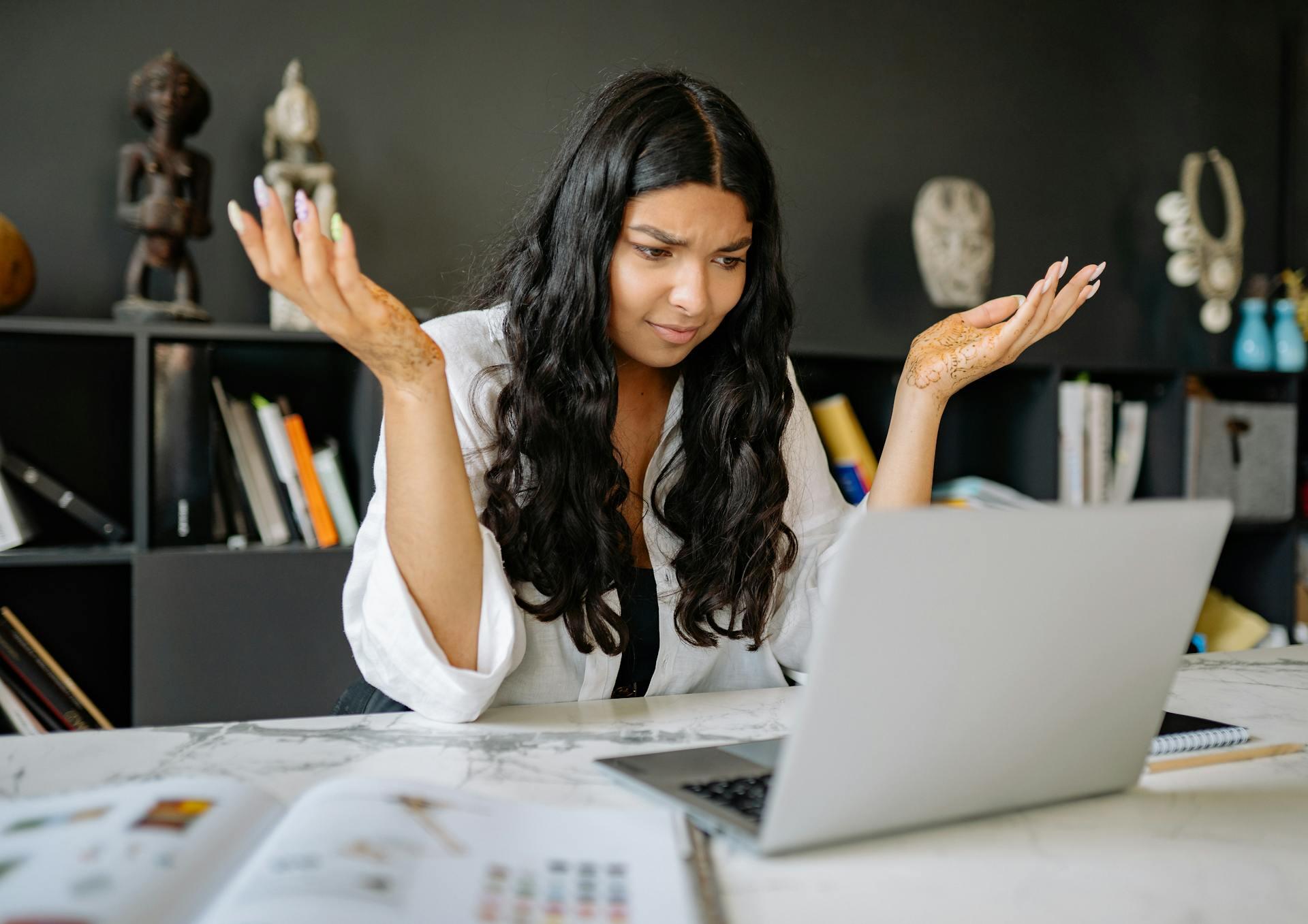 woman sitting at computer looking confused