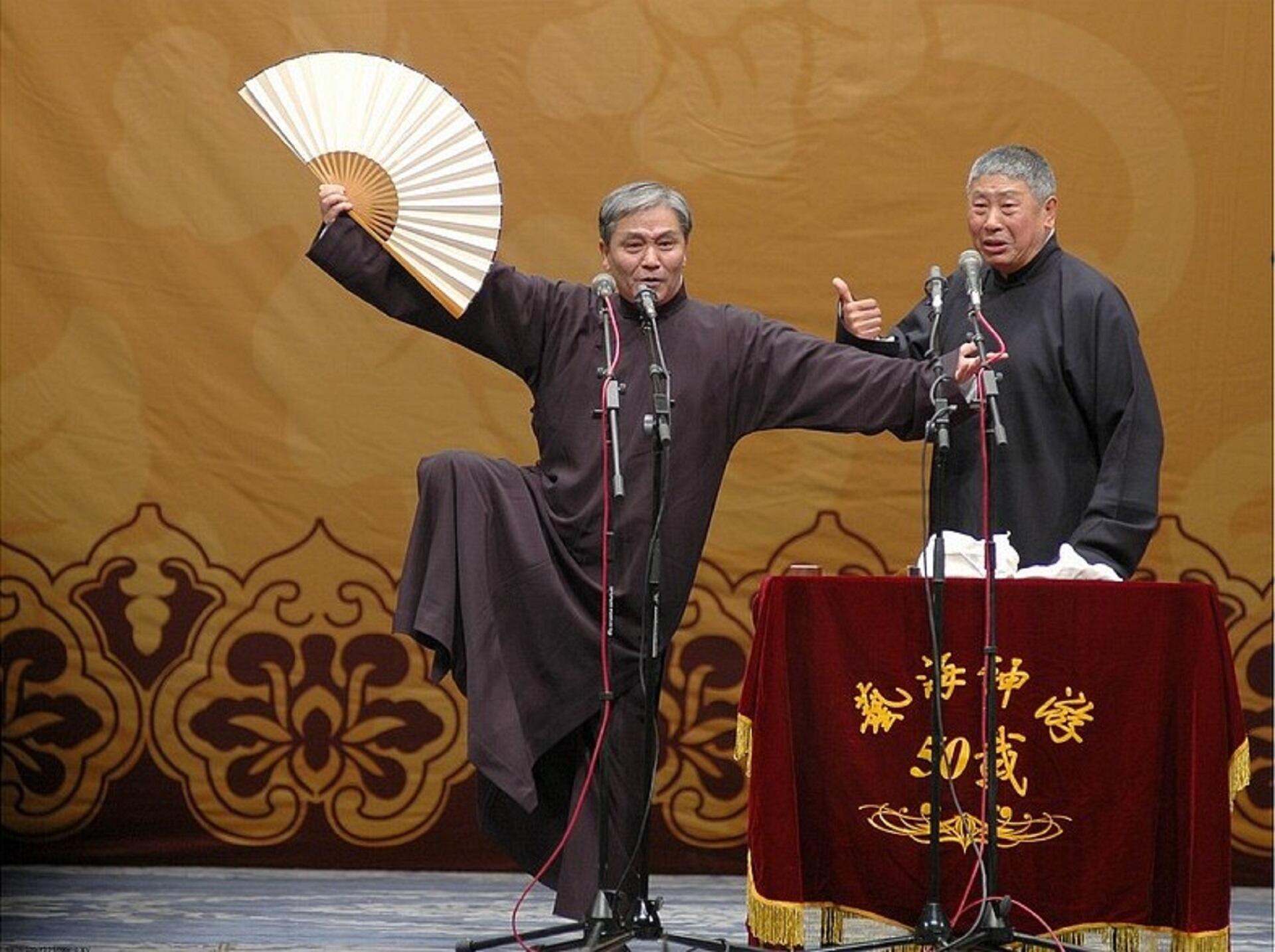 Two men in traditional Chinese changshan on stage.