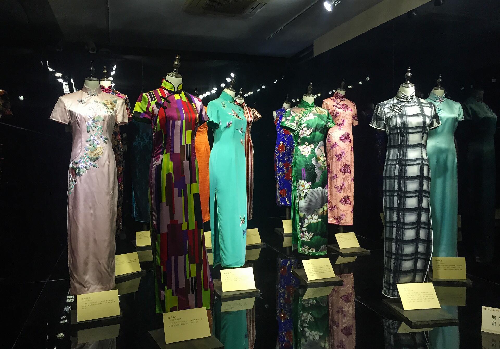 A collection of slim silk dresses on dressmaker forms.