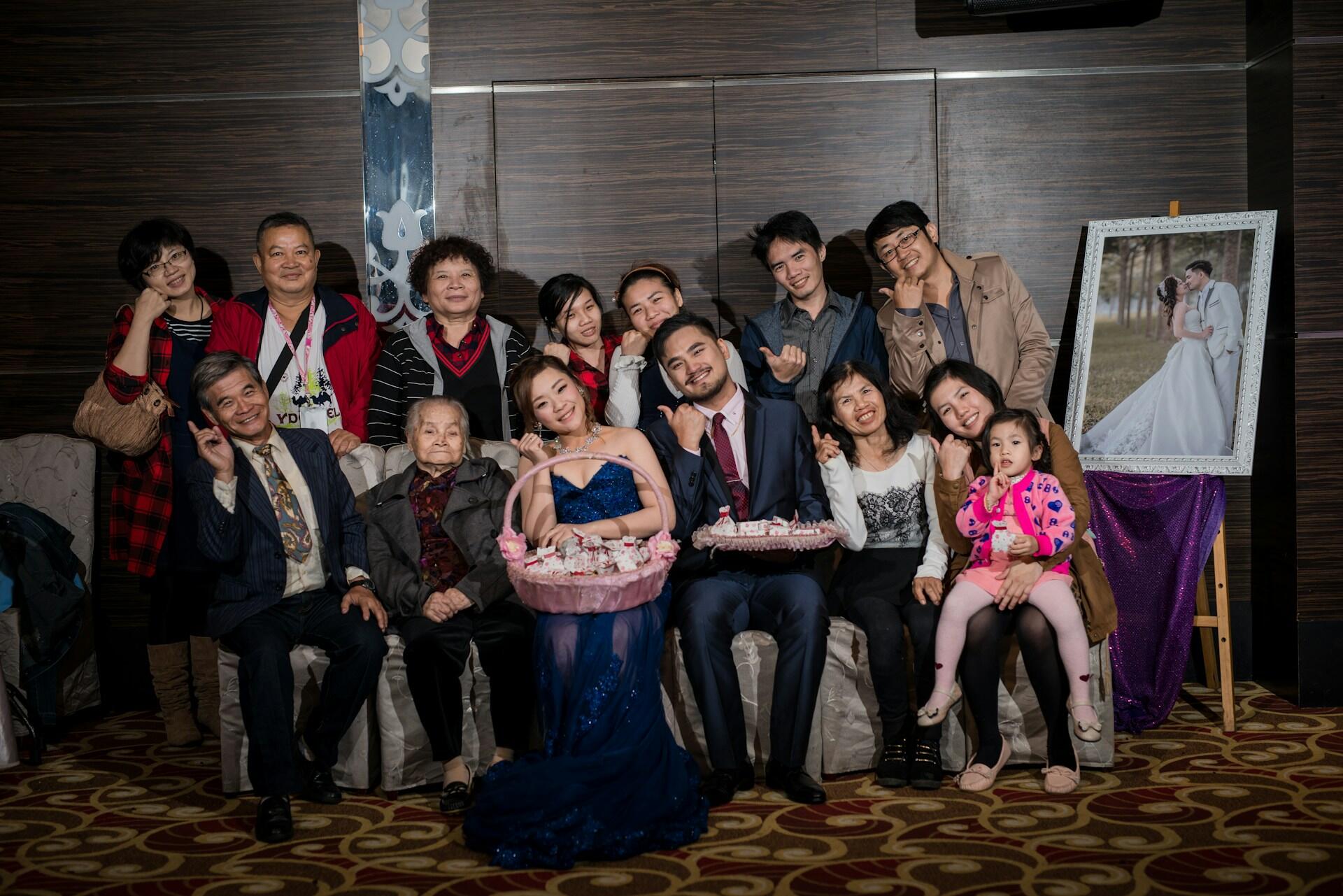 A group of people posed by a wedding portrait. 