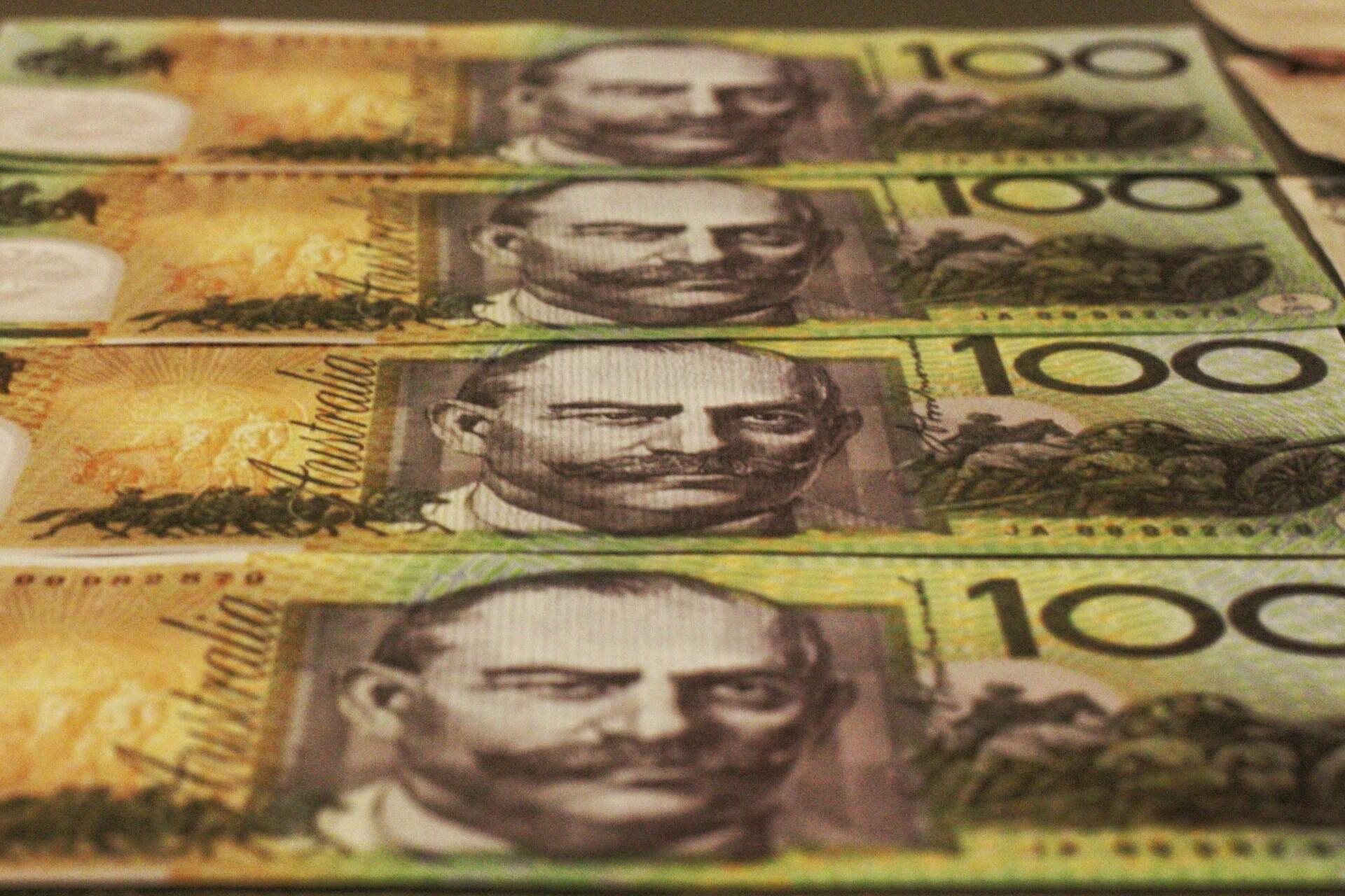 Close-up of stacked Australian one hundred dollar banknotes.