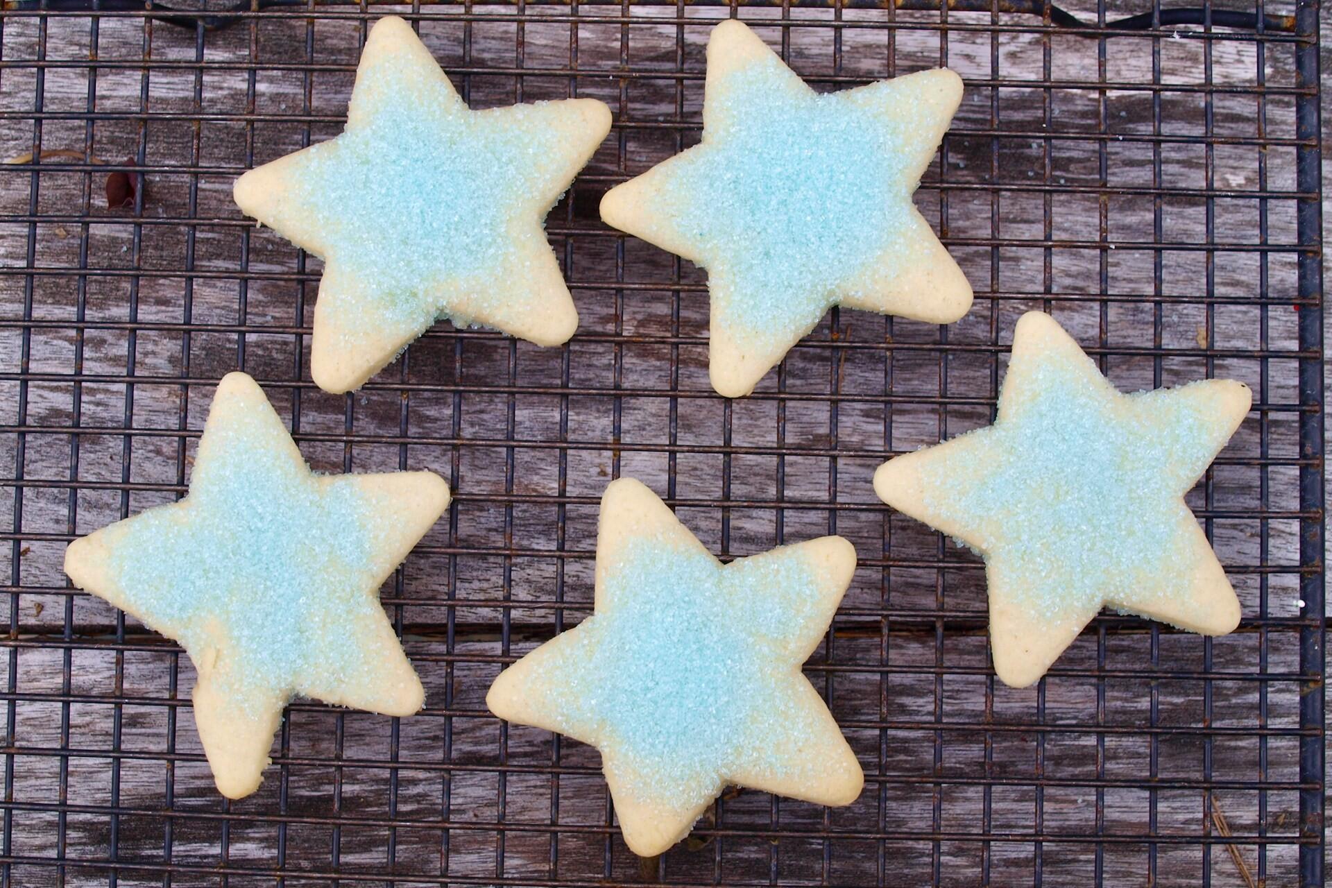 Star-shaped sugar cookies cooling on a wire rack.