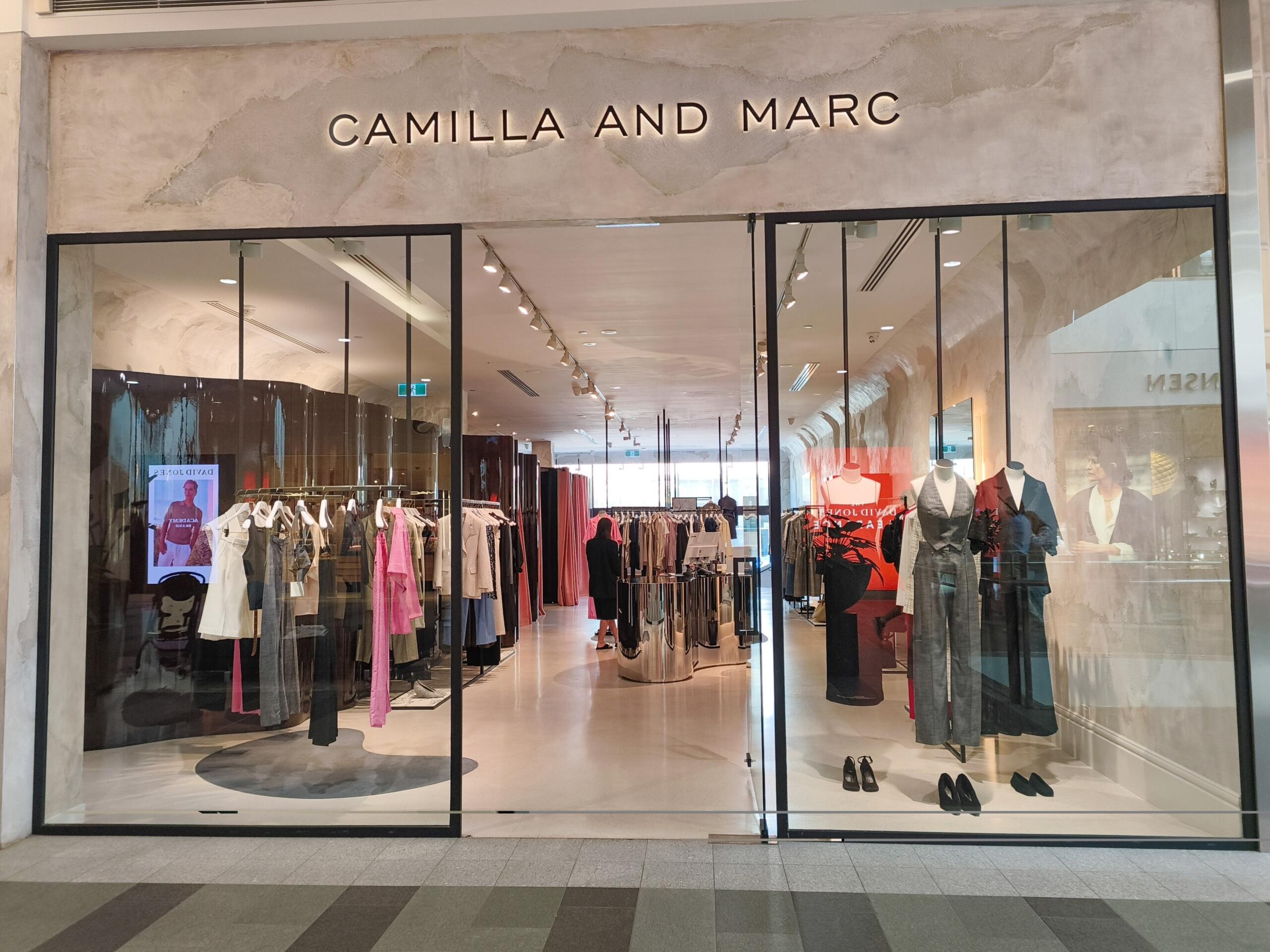 Camilla and Marc storefront with clothing racks and mannequins inside the store