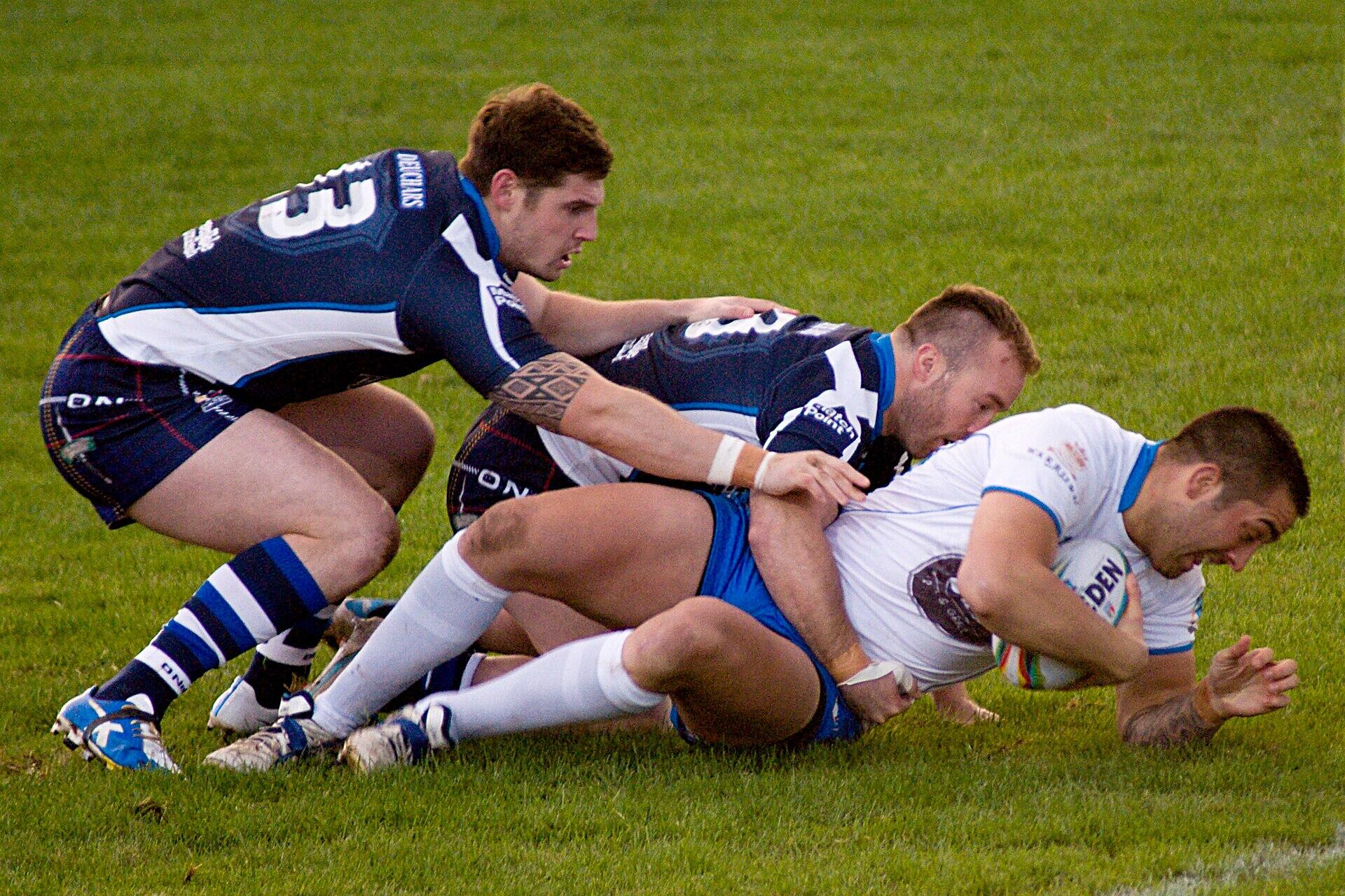 Players making a tackle during the 2013 Rugby League World Cup match.