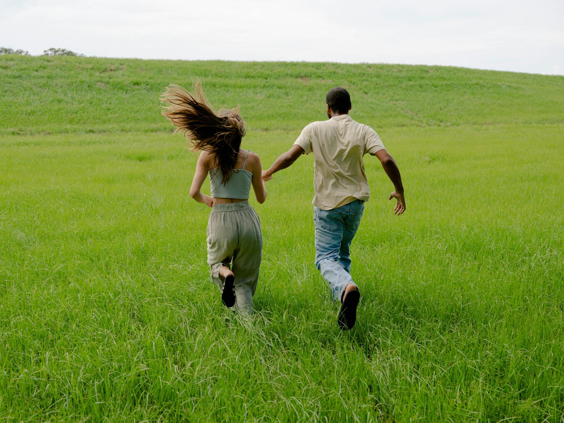man and a woman running in a field