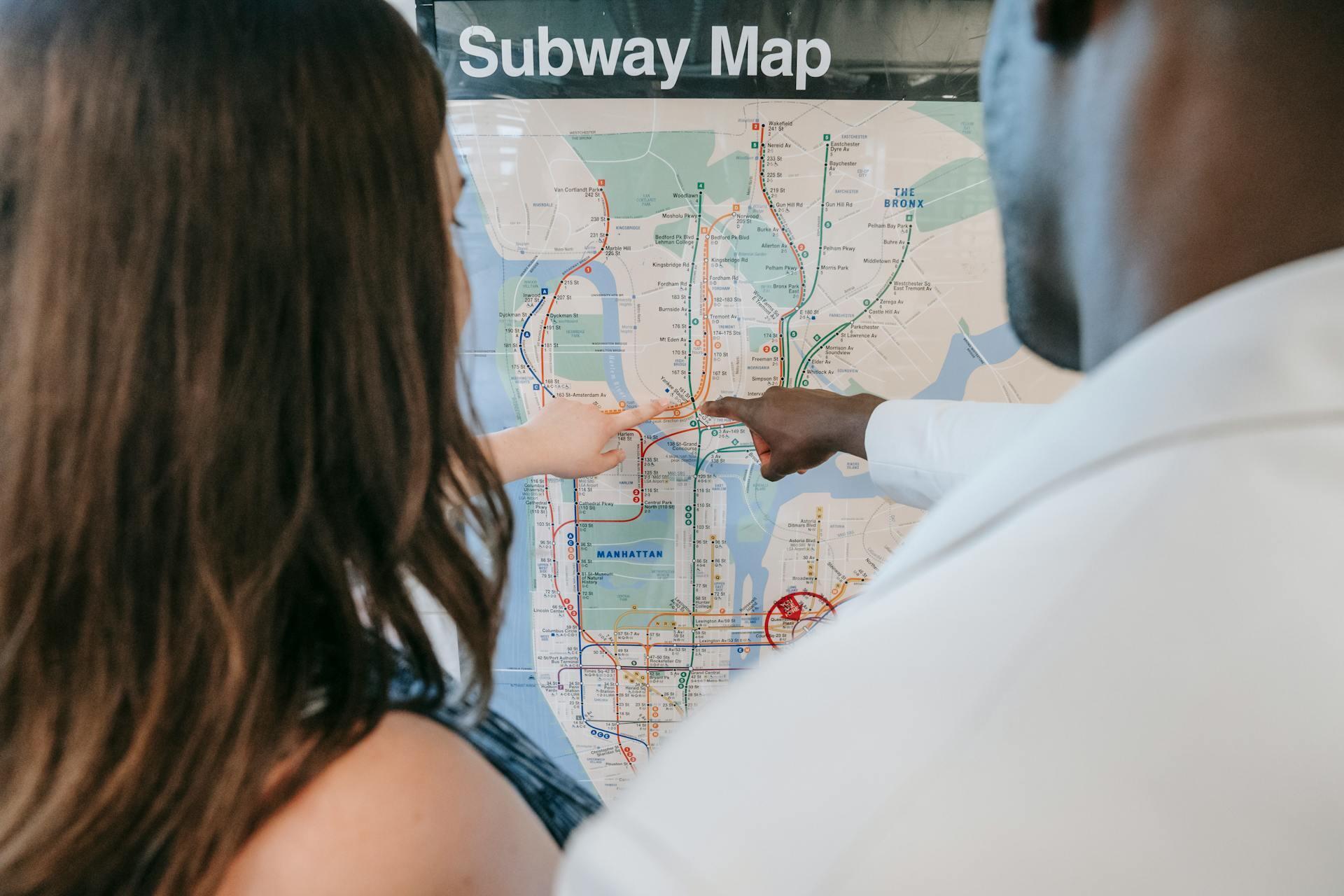 two people using a map to figure out the New York subway system