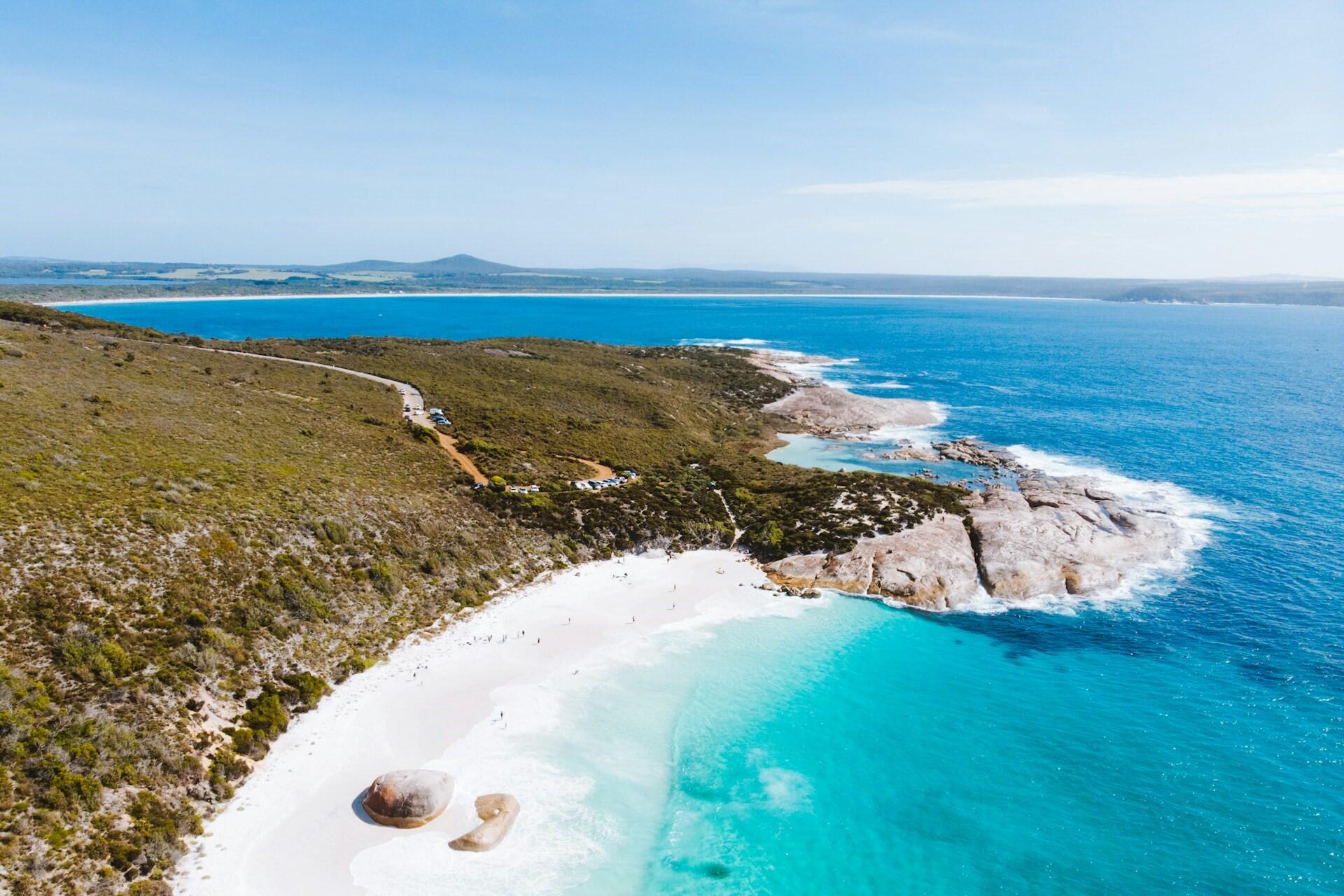 Aerial view of a rocky coastline with turquoise water and sandy beach in Western Australia