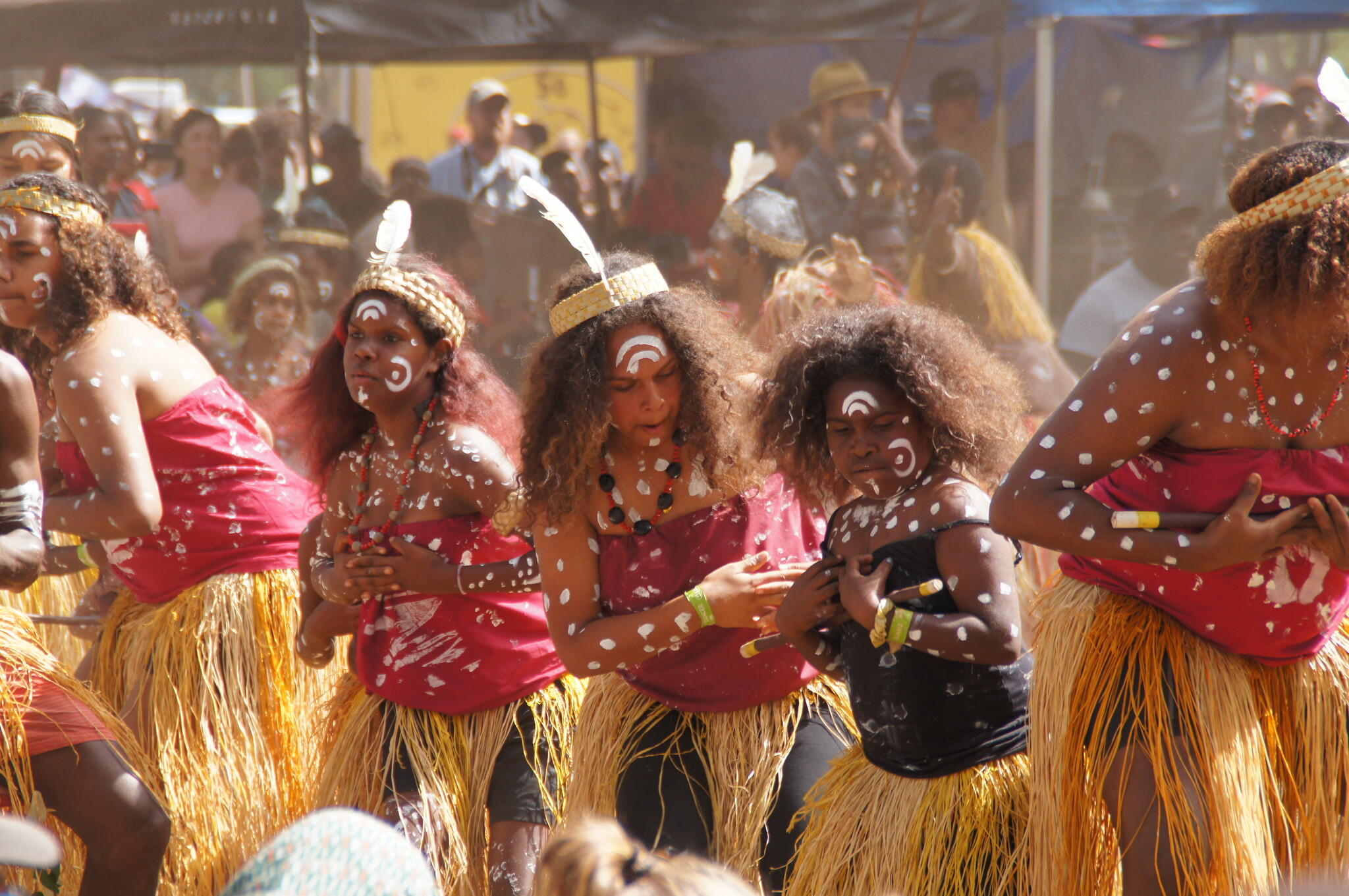 group of Indigenous Australian members dancing a traditional dance with body paint