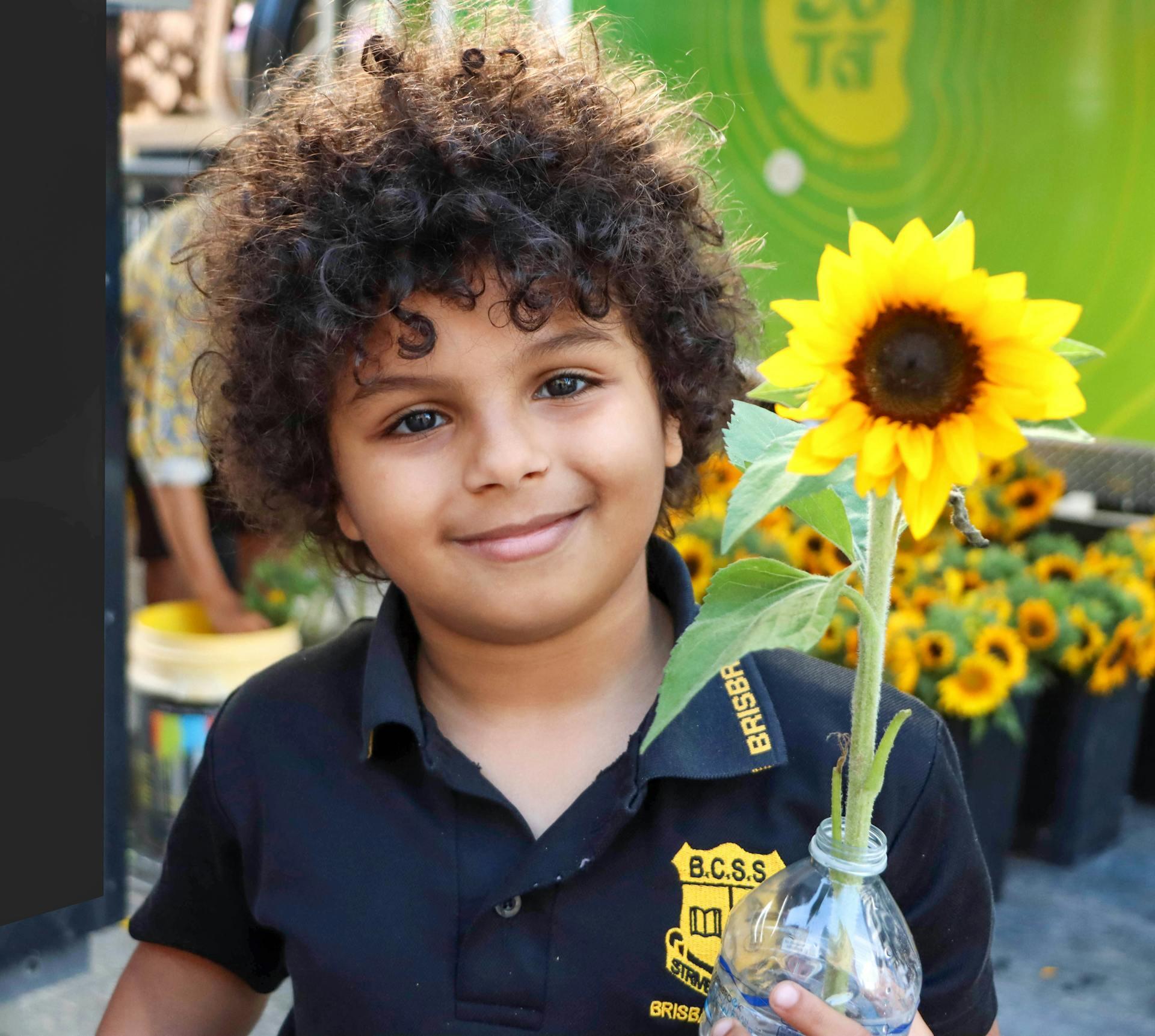a young child holding a sunflower