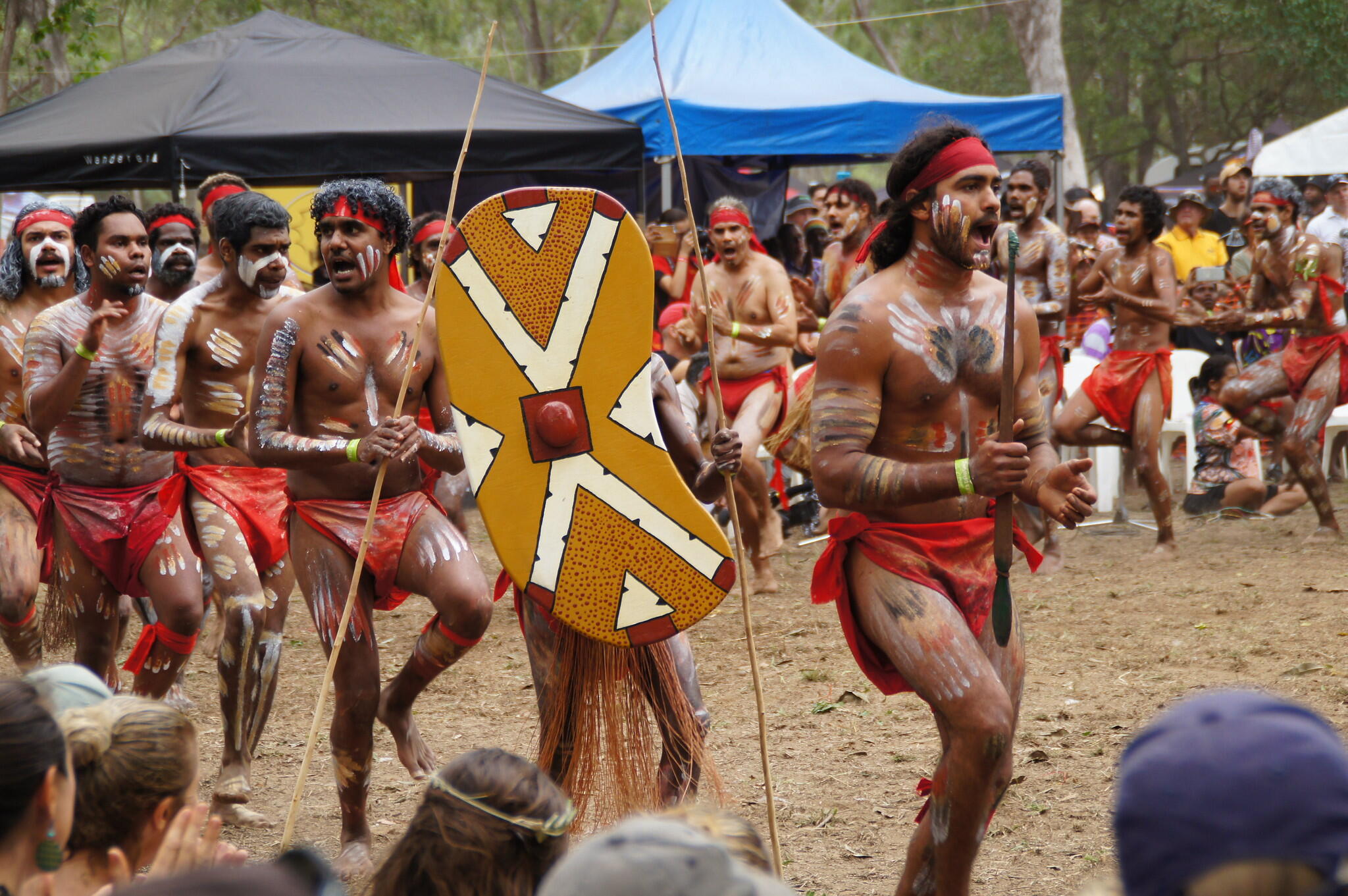 Laura Quinkan Indigenous Dance Festival dancers wearing a traditional body paint, clothes, and shield and spears