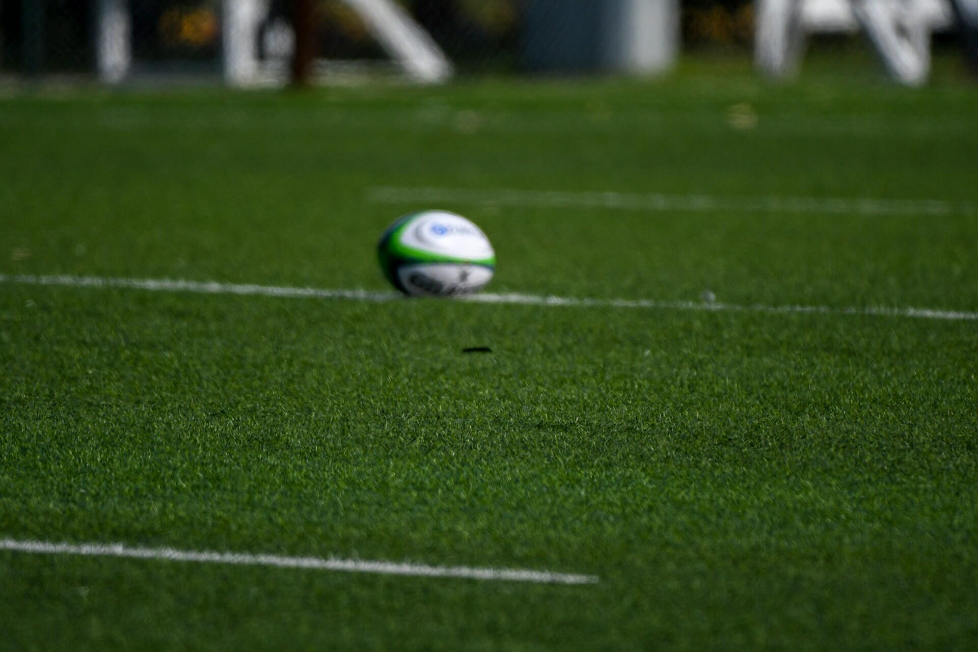 Rugby ball on a grass field with white field markings