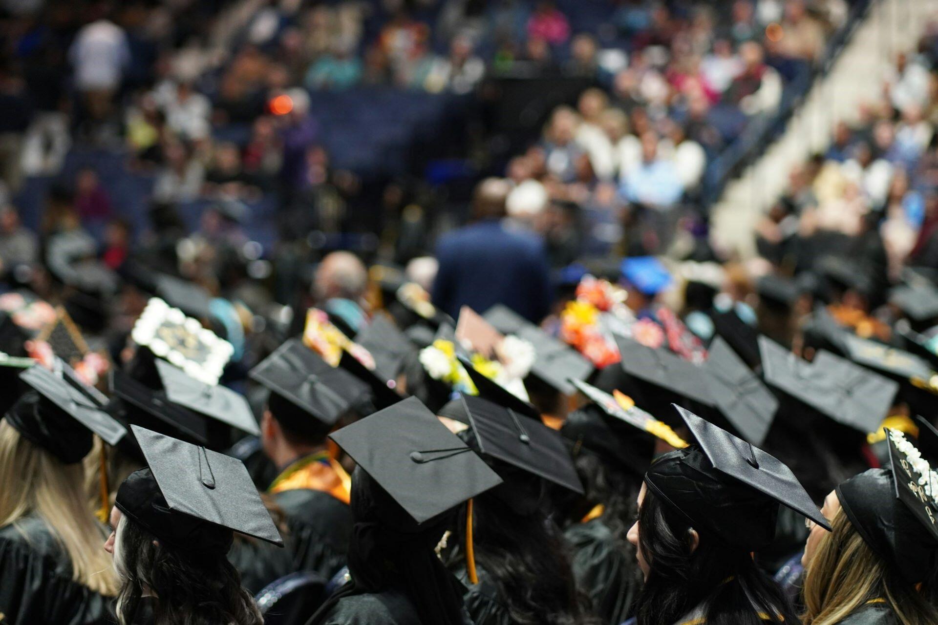 Graduates in black caps seated during a ceremony