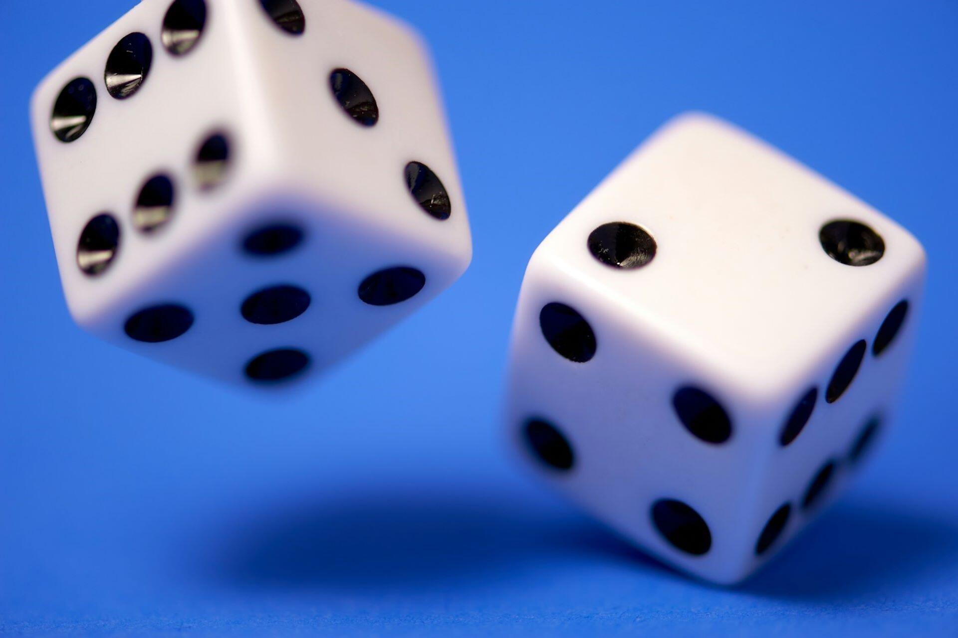 Two white dice on a blue surface.