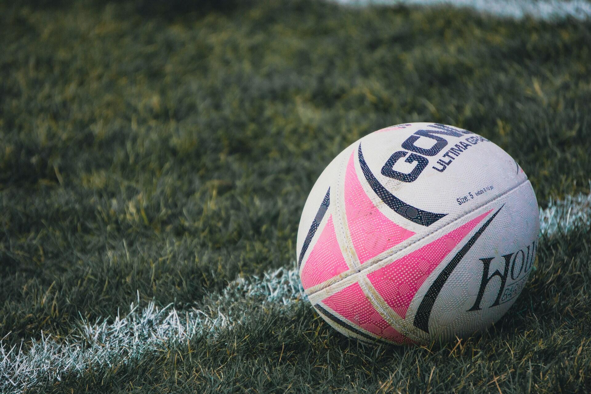 Rugby ball on grass beside a white field line