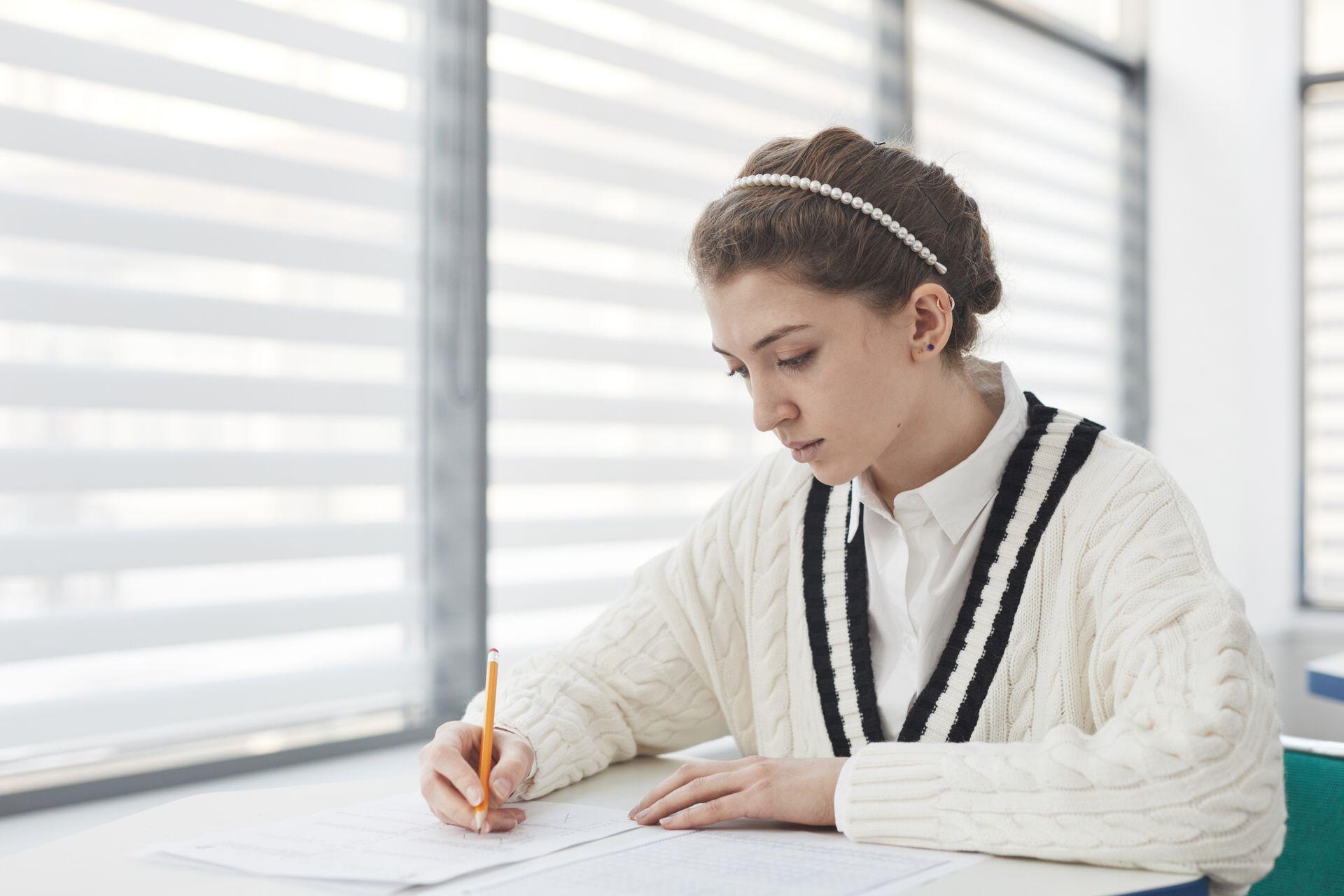 student taking a test in class writing on paper