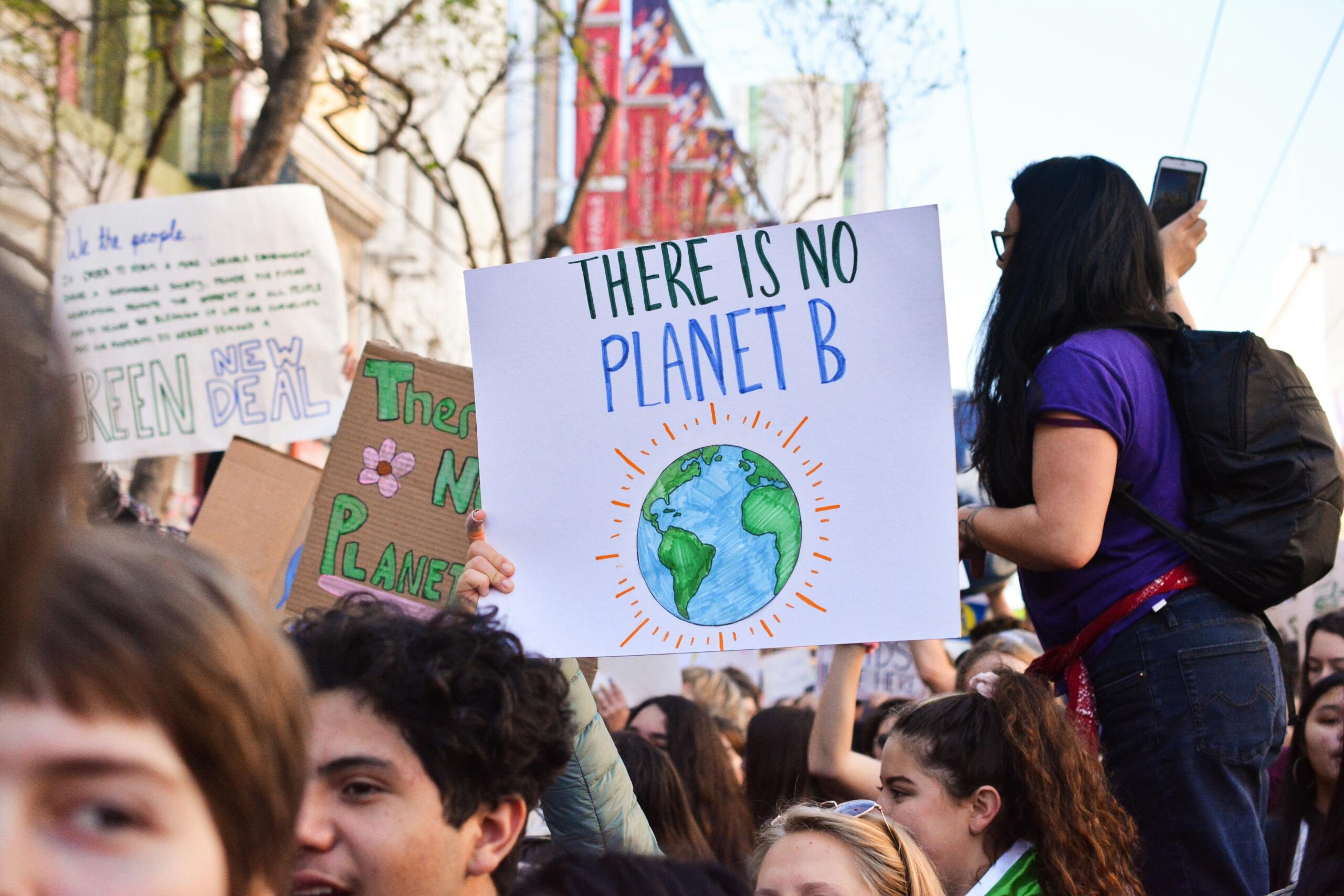Mladi ljudi drže natpis "There is no Planet B" na protestu, vizuelni podsjetnik na važnost ekološke geografije i očuvanja okoliša.