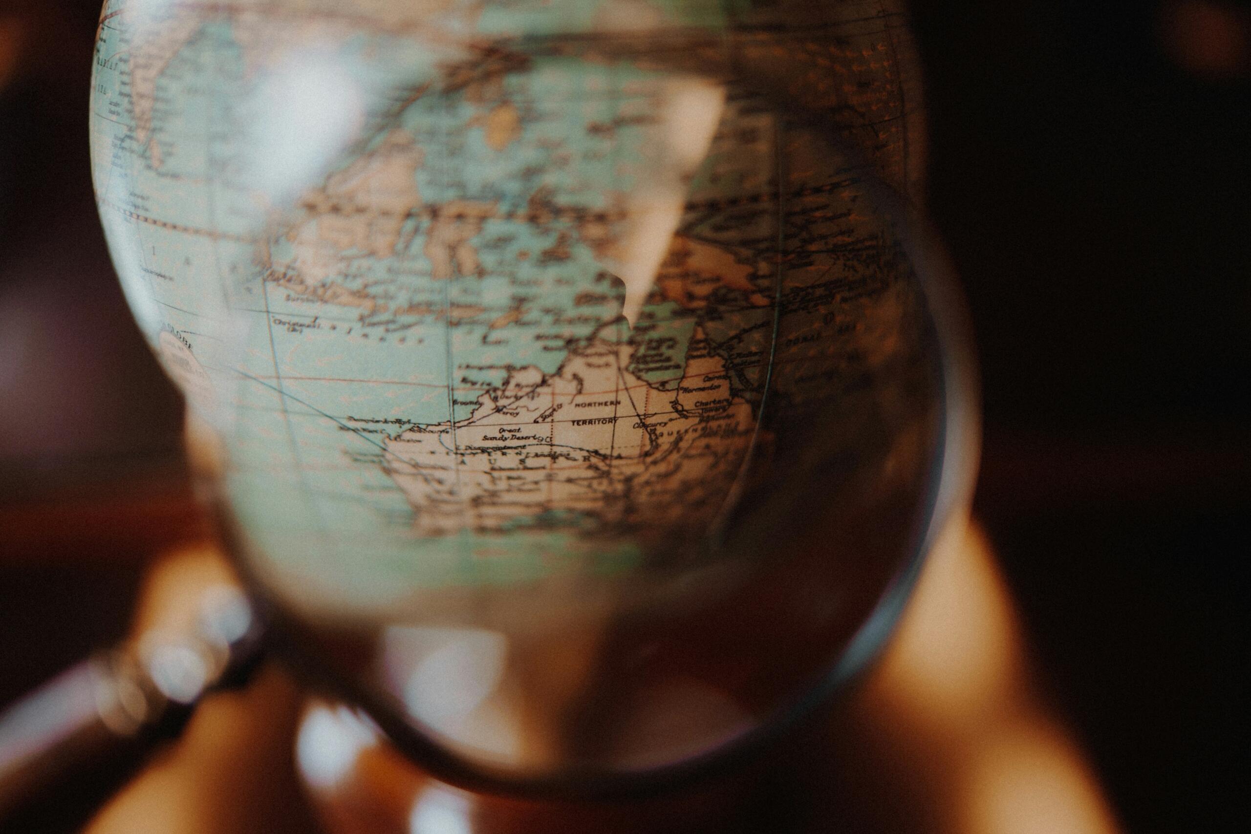 Globus pod lupom, simbol istraživanja, naučnog otkrivanja i historije geografije.