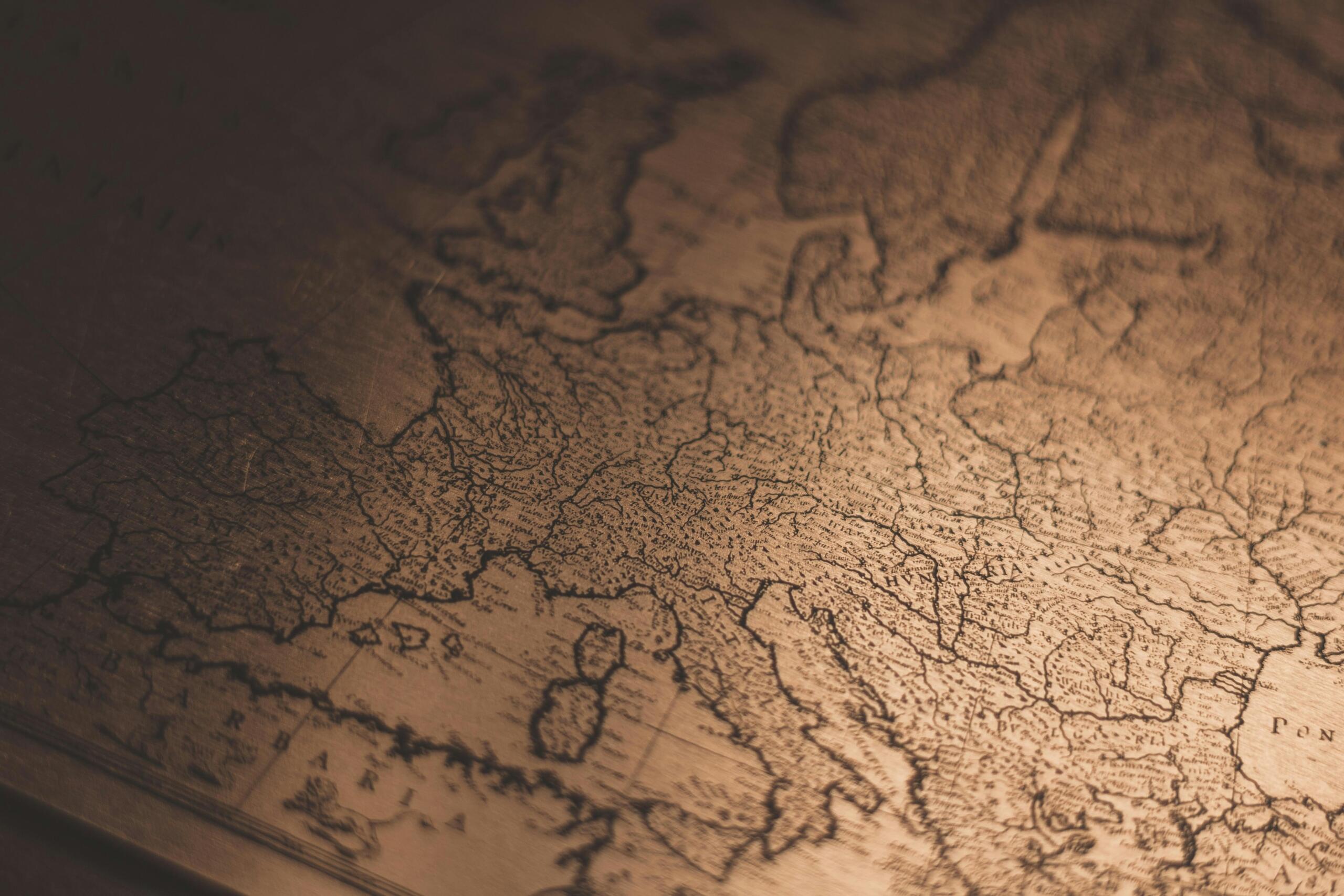 Staronjemački jezik – krupni plan na staru patiniranu geografsku kartu Evrope sa graviranim granicama, historijskim regijama i starim nazivima.