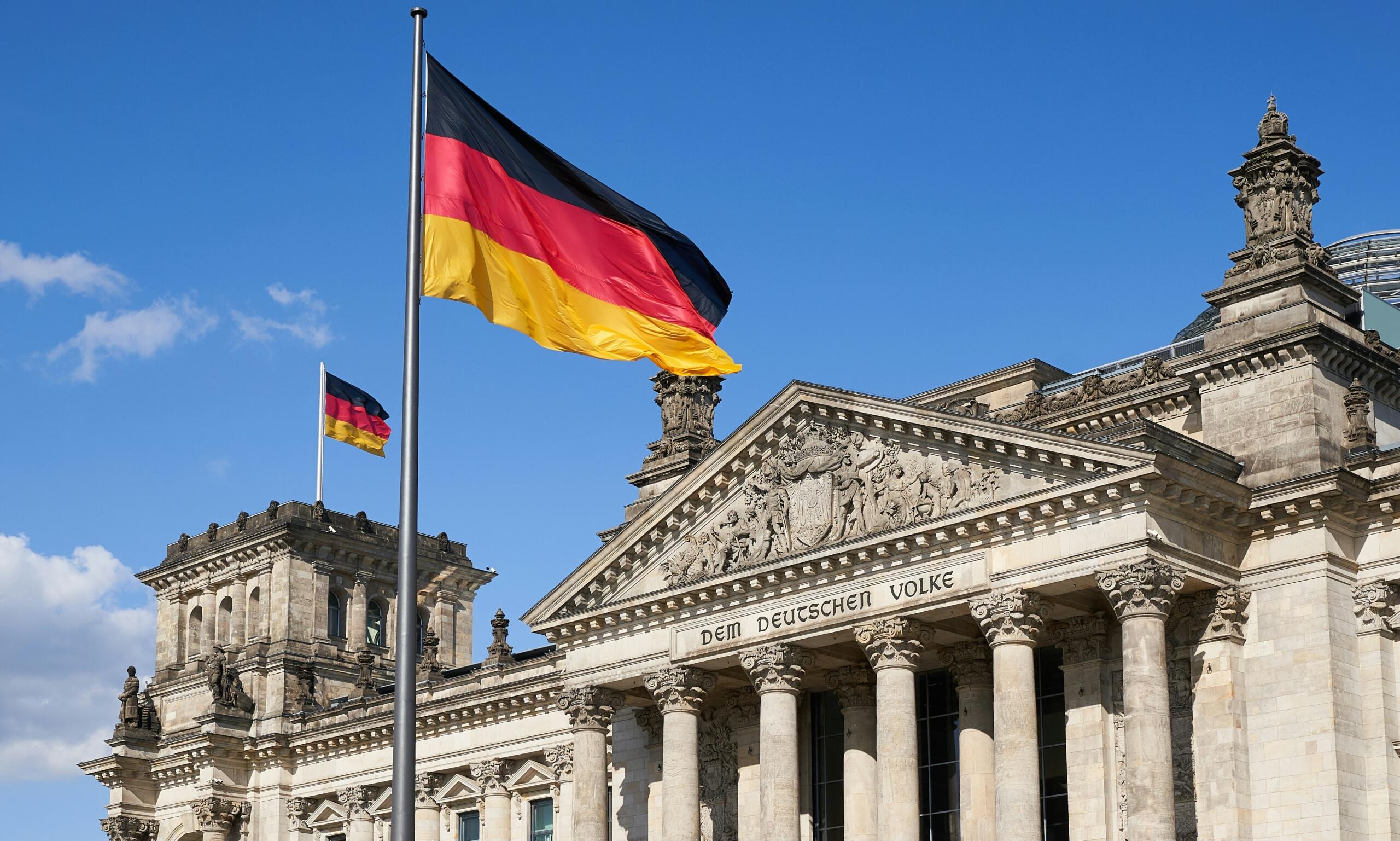 Zapadnogermanski jezici – zgrada njemačkog parlamenta Reichstag u Berlinu sa staklenom kupolom pod plavim nebom.