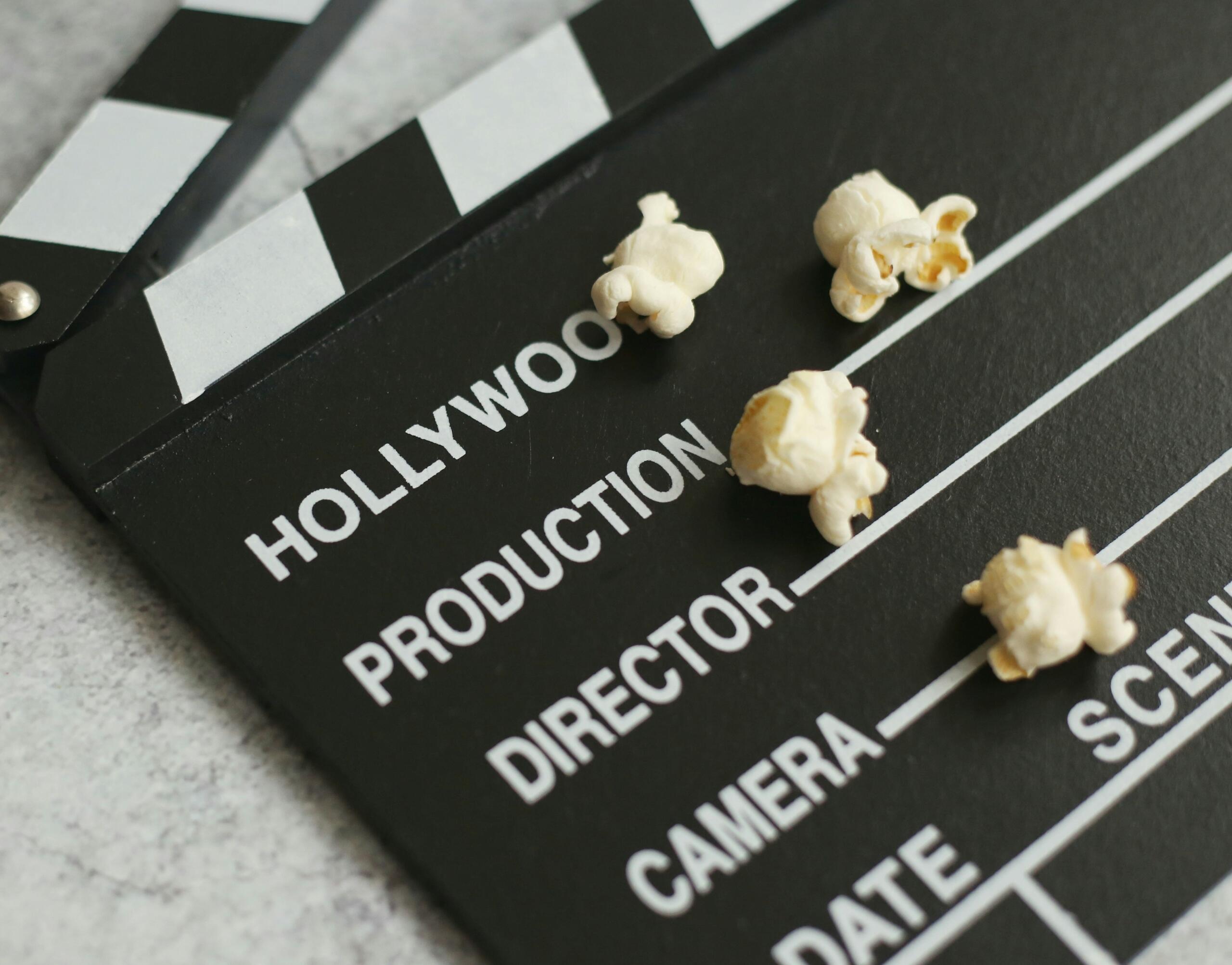 Posuda s kokicama i filmska traka na tamnoj pozadini koji simboliziraju gledanje filmova i serija