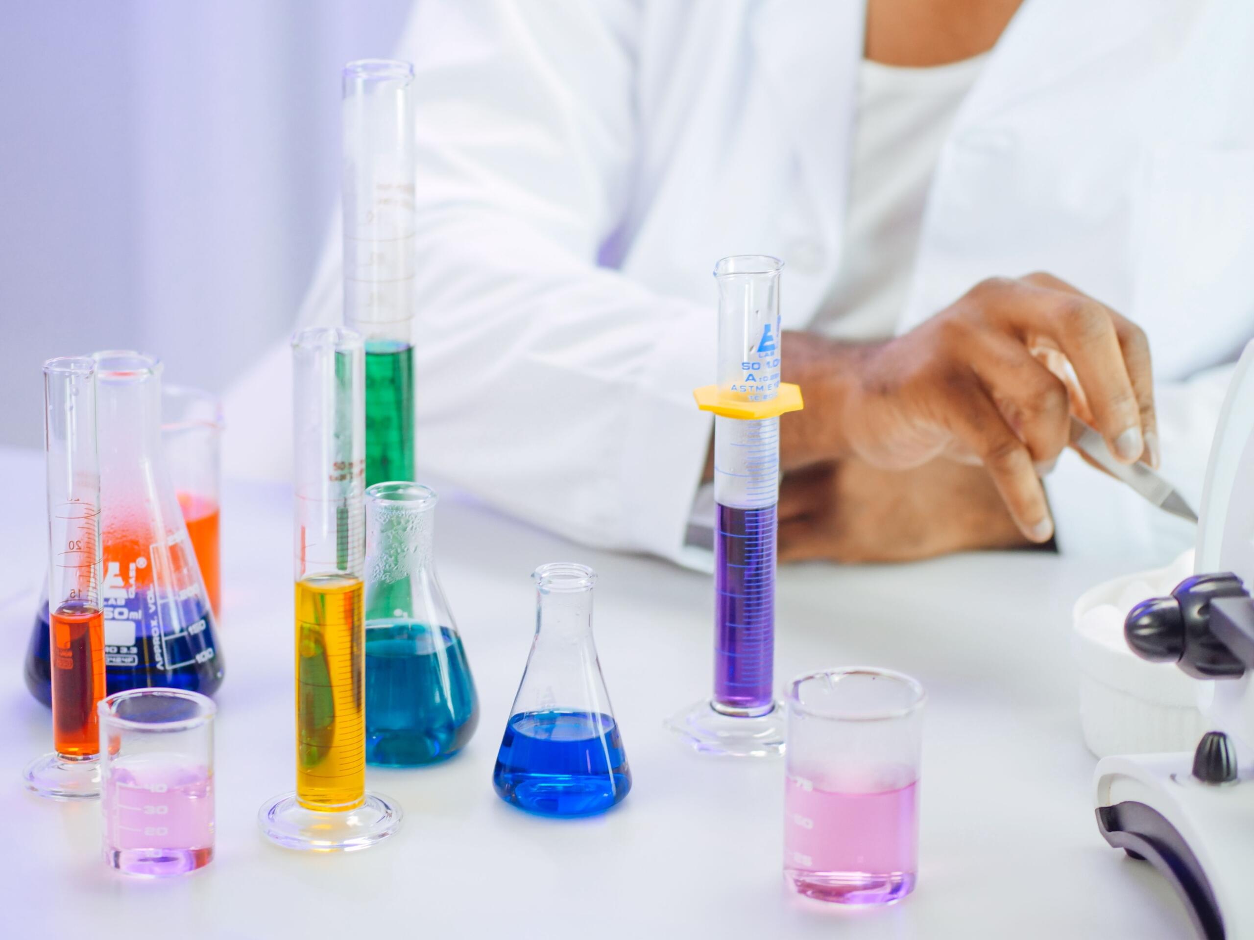 Laboratorijske staklene posude i epruvete napunjene plavim, žutim i crvenim tečnostima