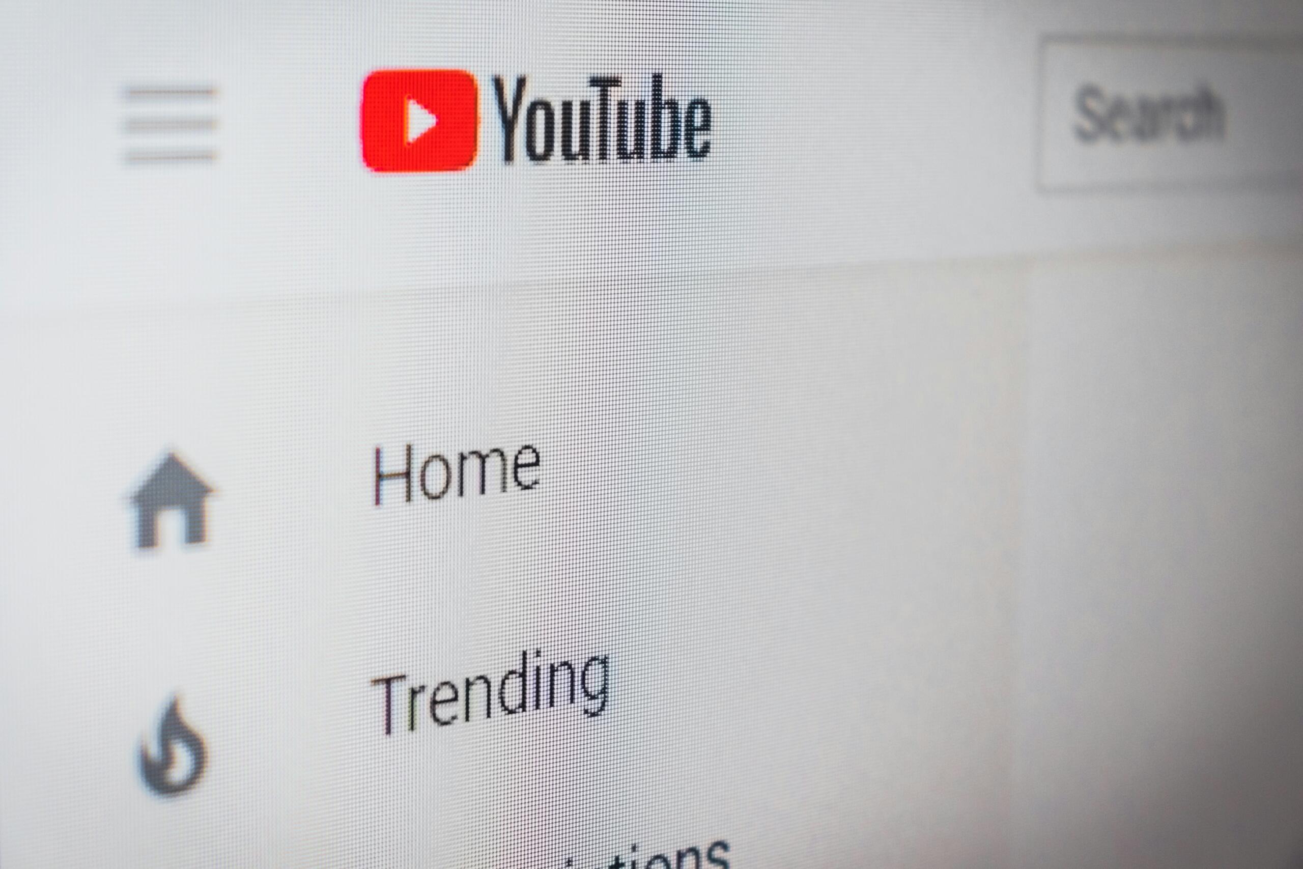 Detaljan prikaz ekrana sa crvenim YouTube logotipom i opcijama za pretragu