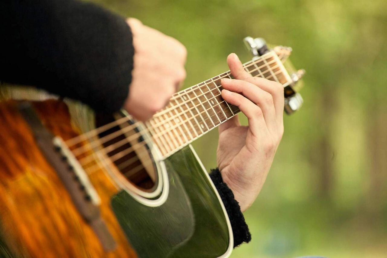 personne jouant de la guitare dans l herbe