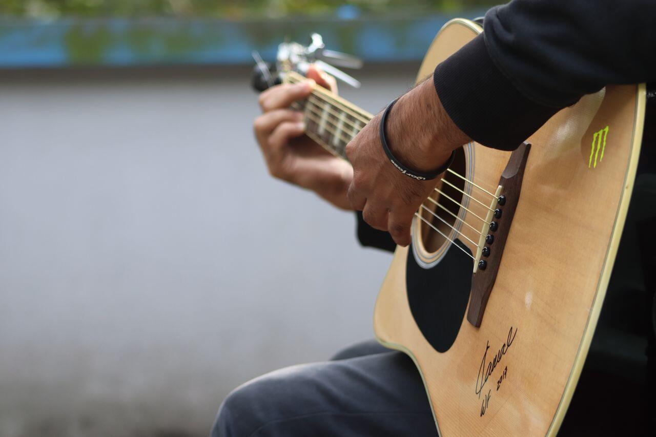 homme dehors jouant de la guitare