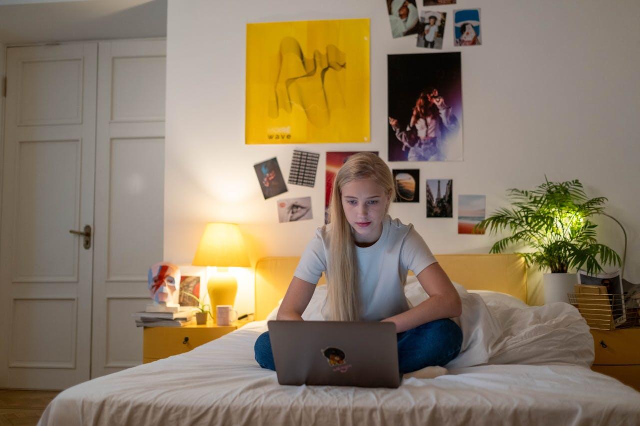 ado sur son ordi dans sa chambre