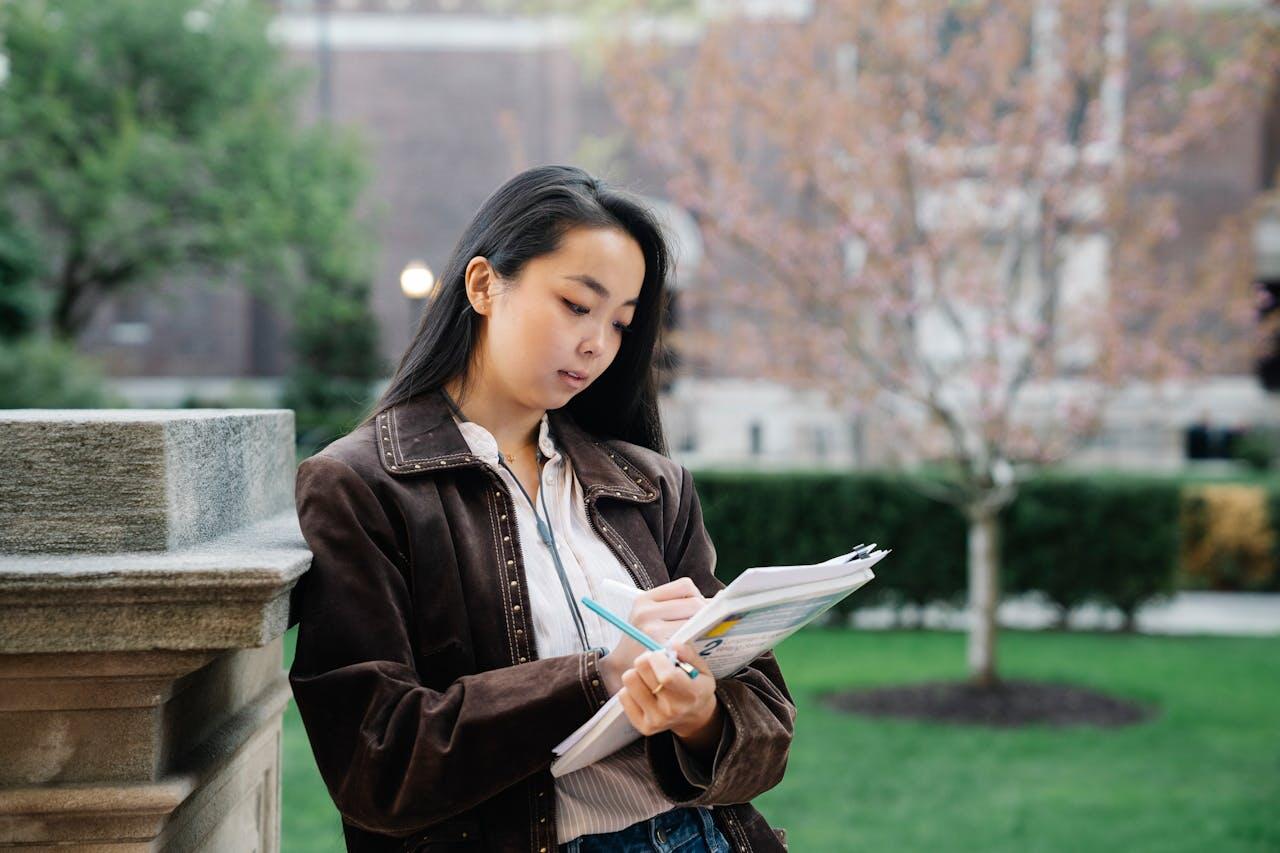jeune femme dehors etudiant ses documents