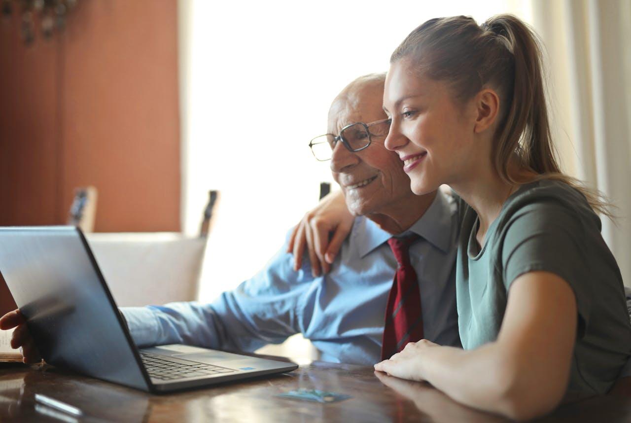 petite-fille et son grand-père tout sourire devant l ordinateur