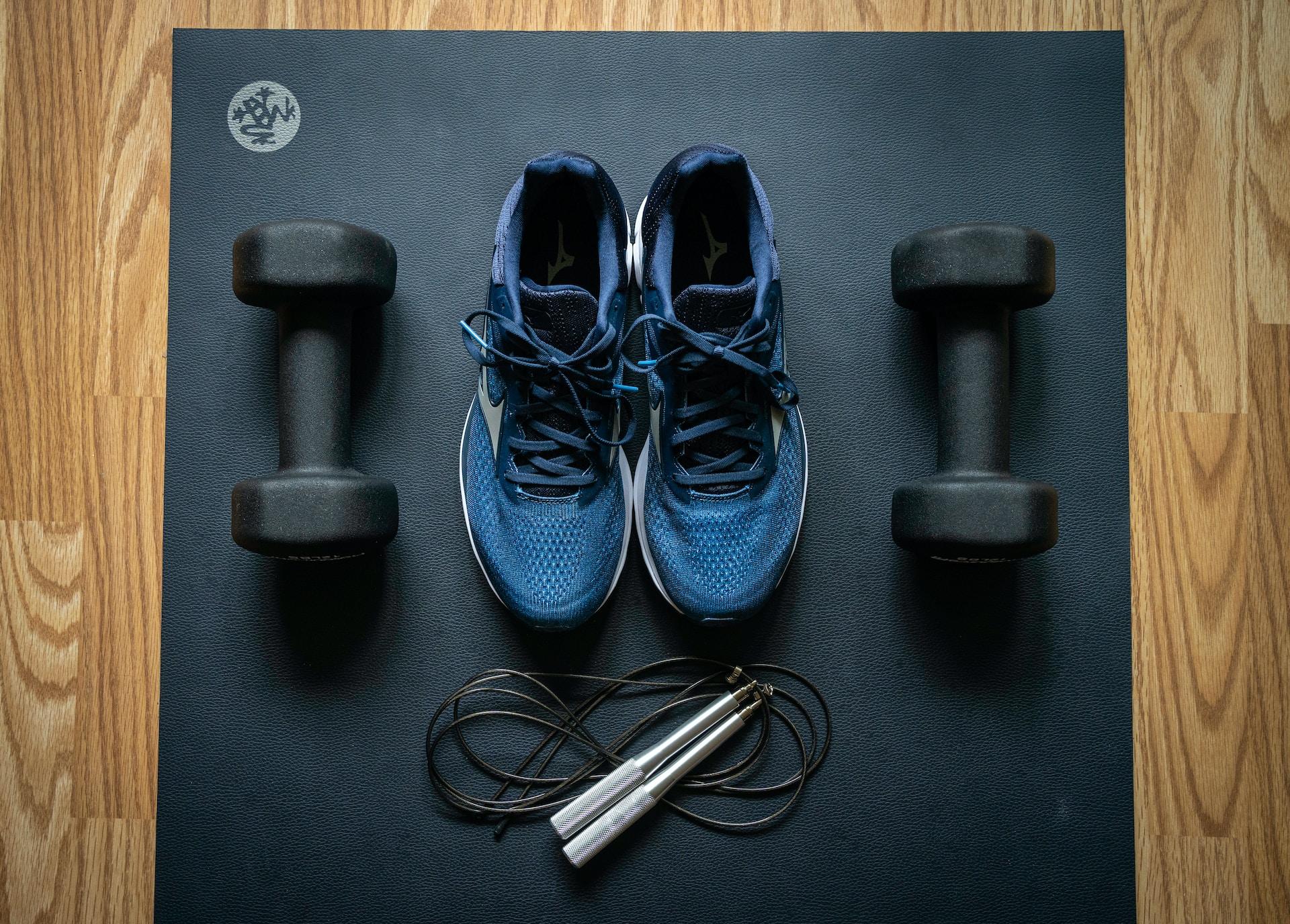 chaussures et poids posés sur sol de salle de sport