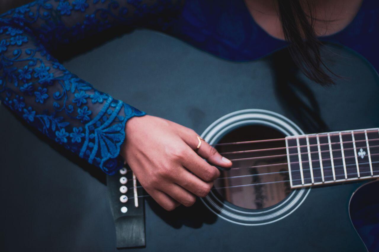 femme en bleu jouant sur une guitare bleue