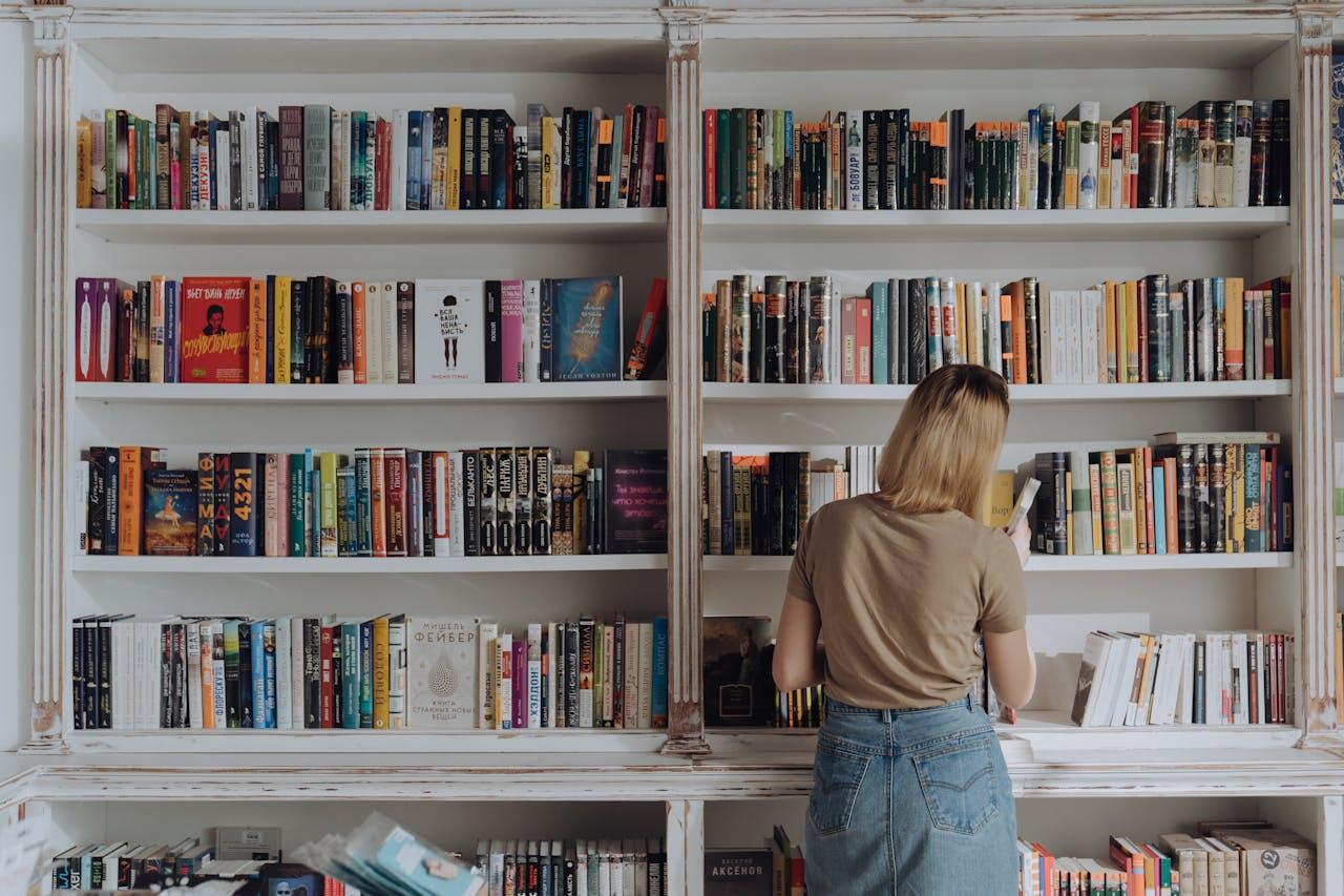jeune femme devant deux etageres blanches d une bibliotheque