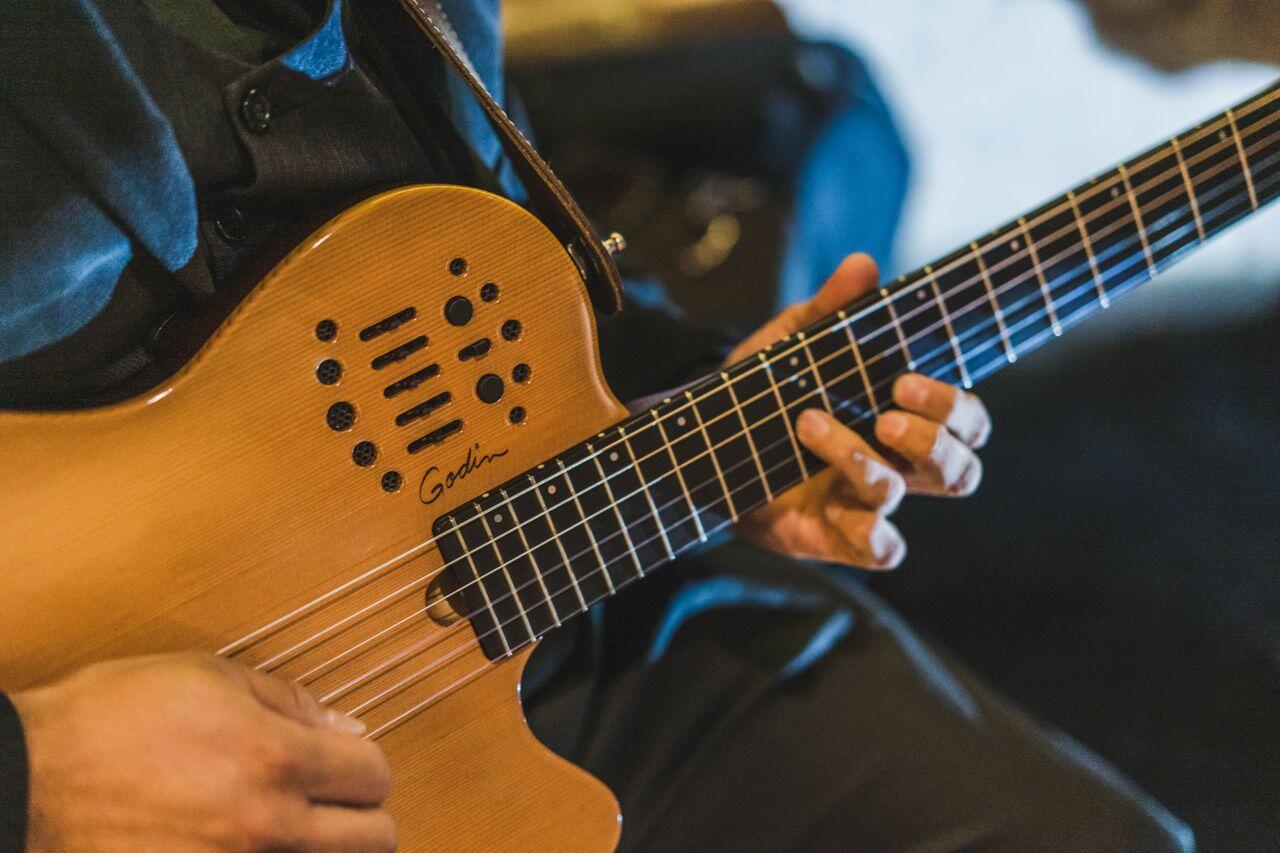 homme veste en cuir jouant de la guitare