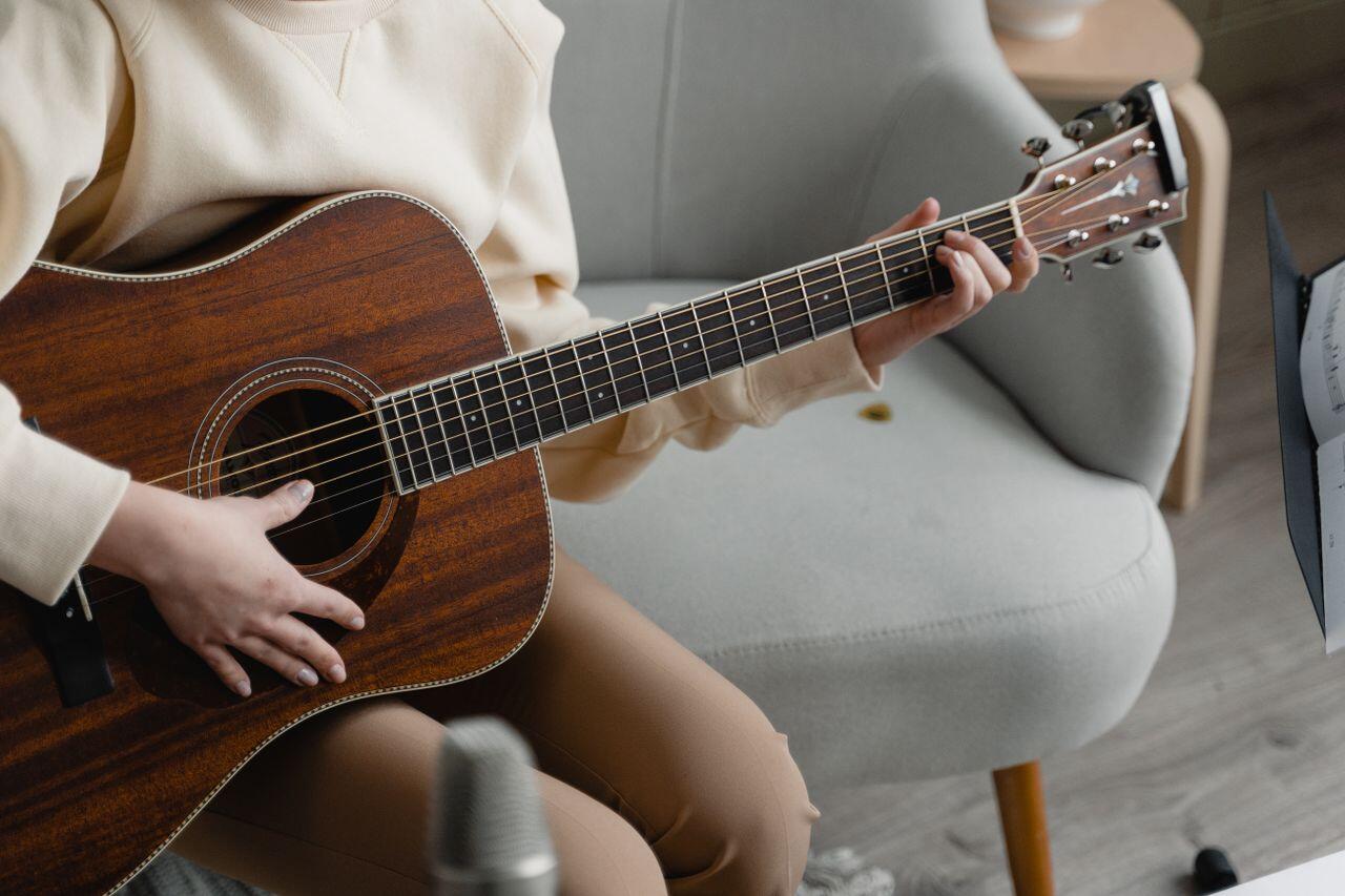 personne jouant de la guitare sur un canapé