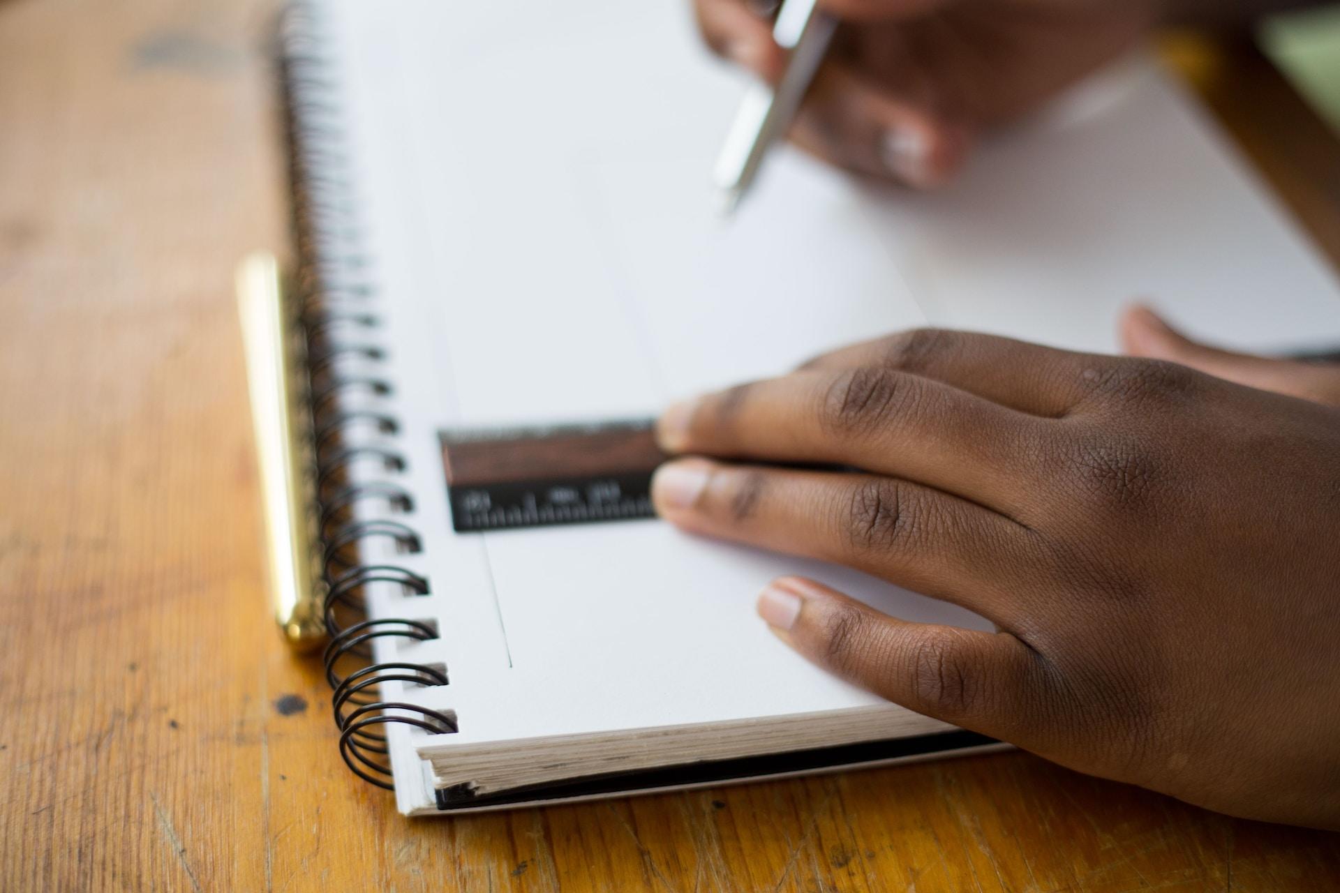 garçon écrivant avec son crayon gris près d'une règle