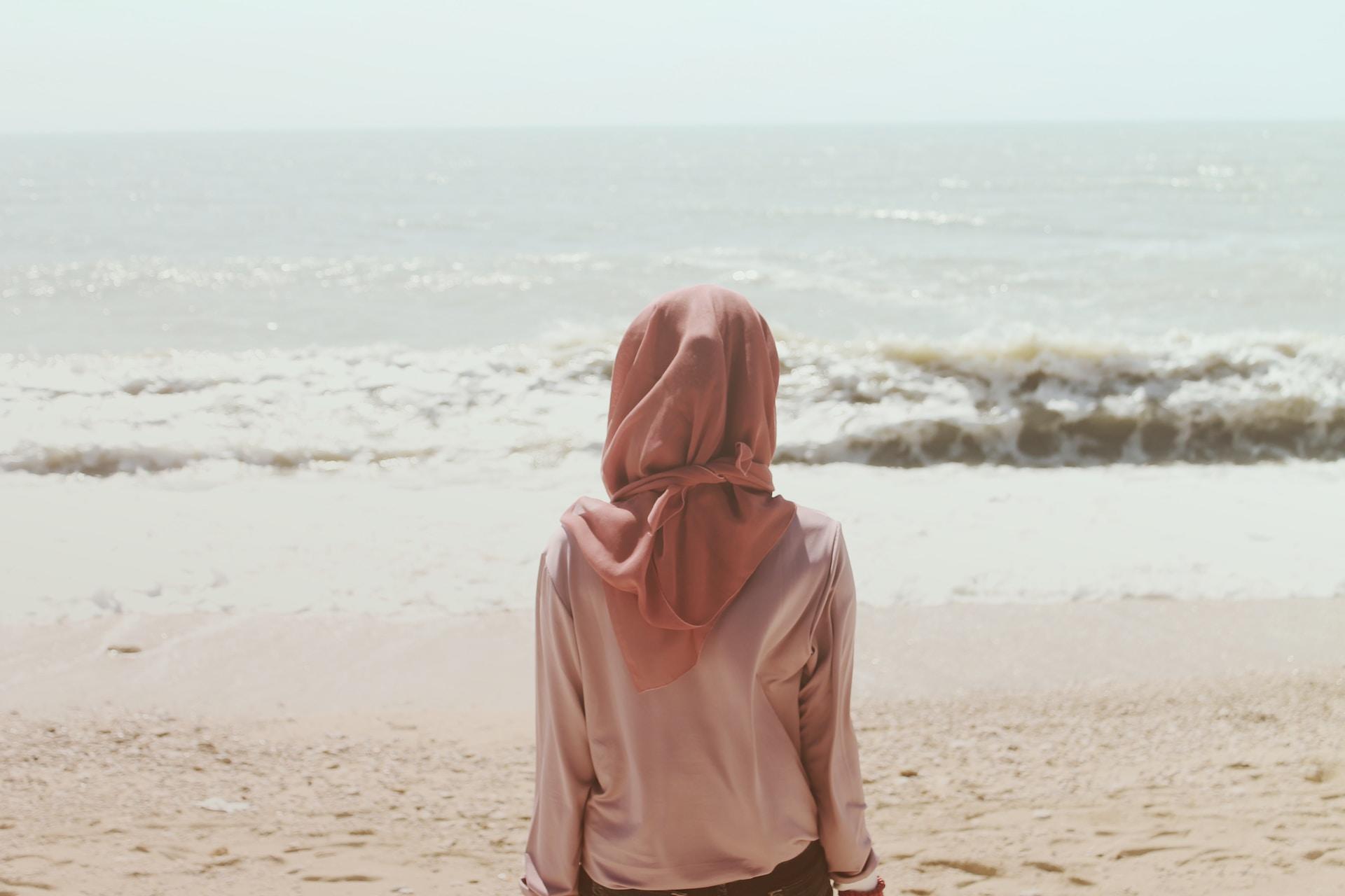 femme voilée sur la plage devant la mer
