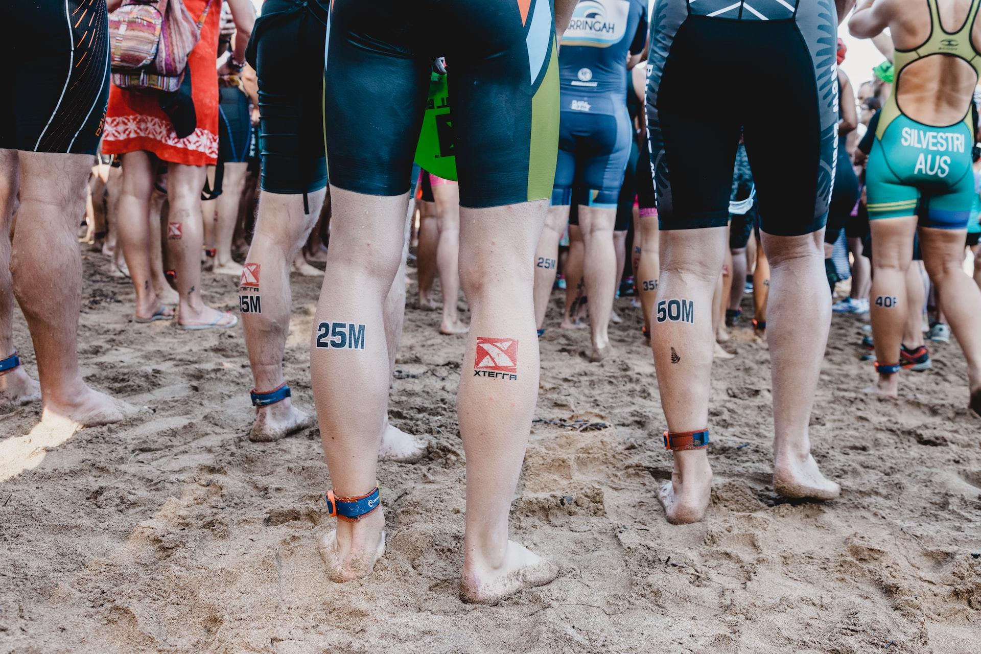 jambes de groupe de sportifs réunis sur une plage