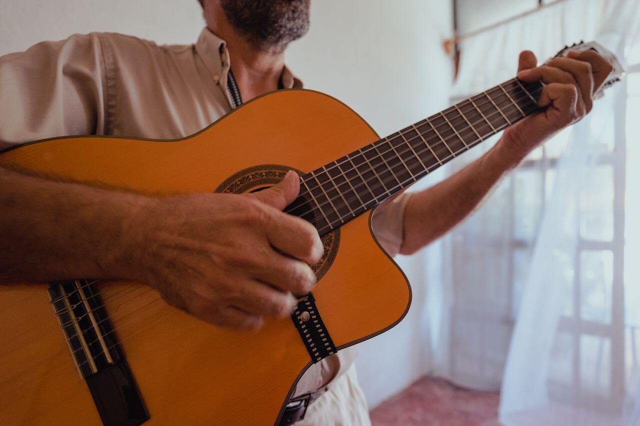 homme barbu jouant de sa guitare