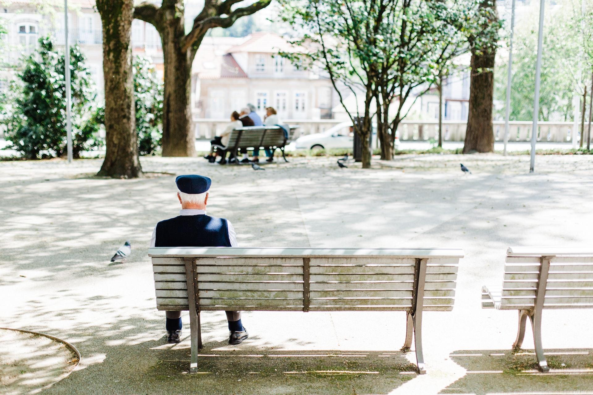 monsieur assis dans un parc sur un banc