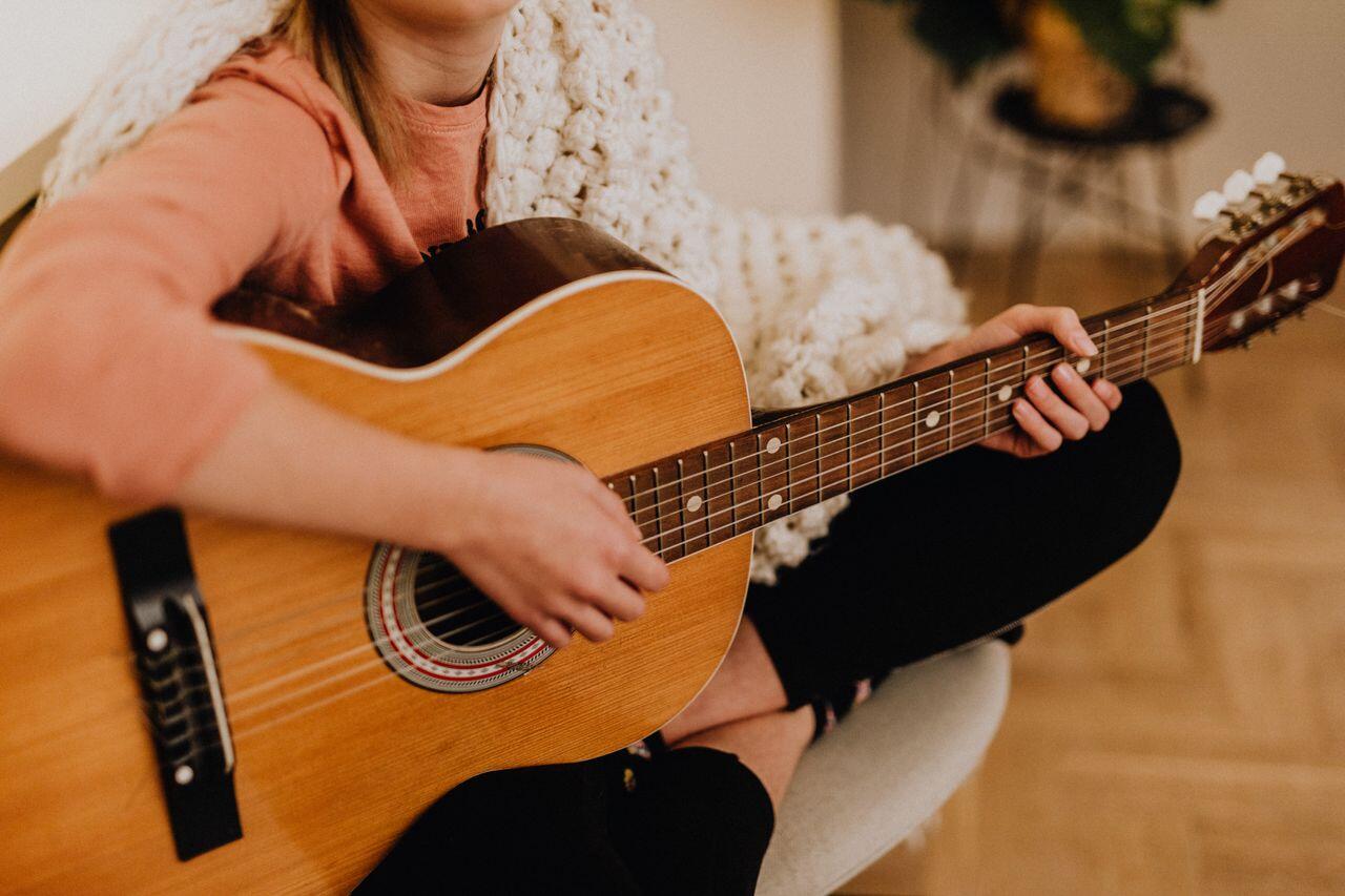 fille en tailleur avec plaid et guitare